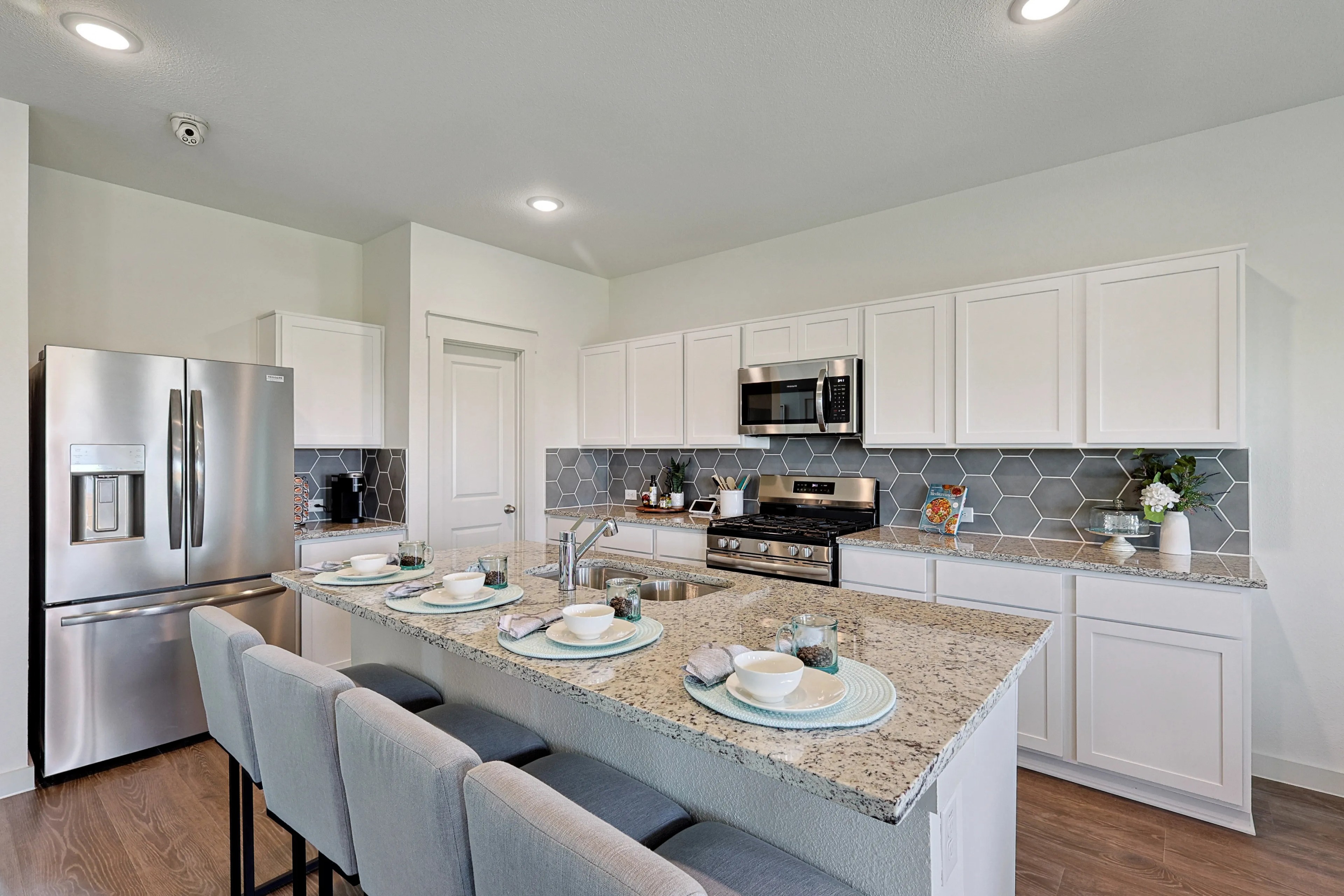 Patriot Estates Kitchen with Granite and Hexagonal Backsplash Modern kitchen with granite countertops, hexagonal backsplash, stainless appliances in Patriot Estates.