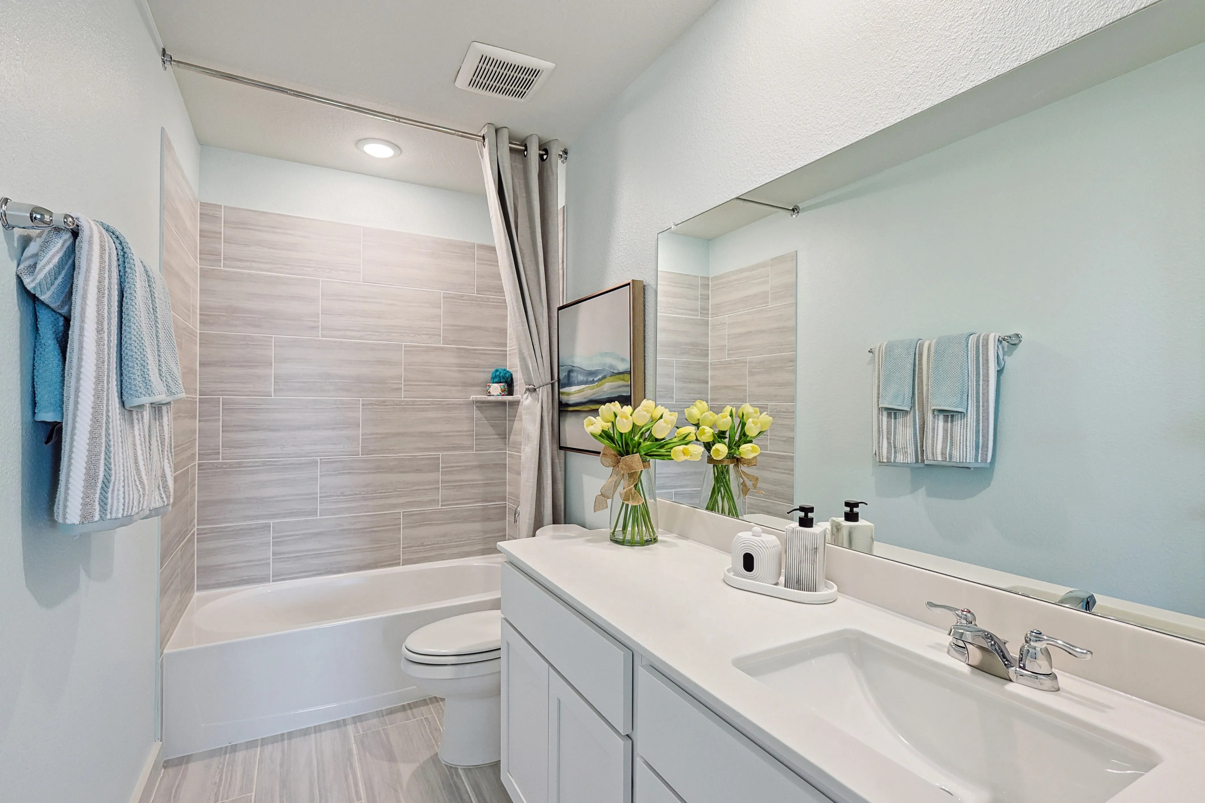 Modern Bathroom Design in Patriot Estates with Elegant Gray Tiles Elegant bathroom with light gray tiles, modern fixtures, and fresh tulips, Patriot Estates.