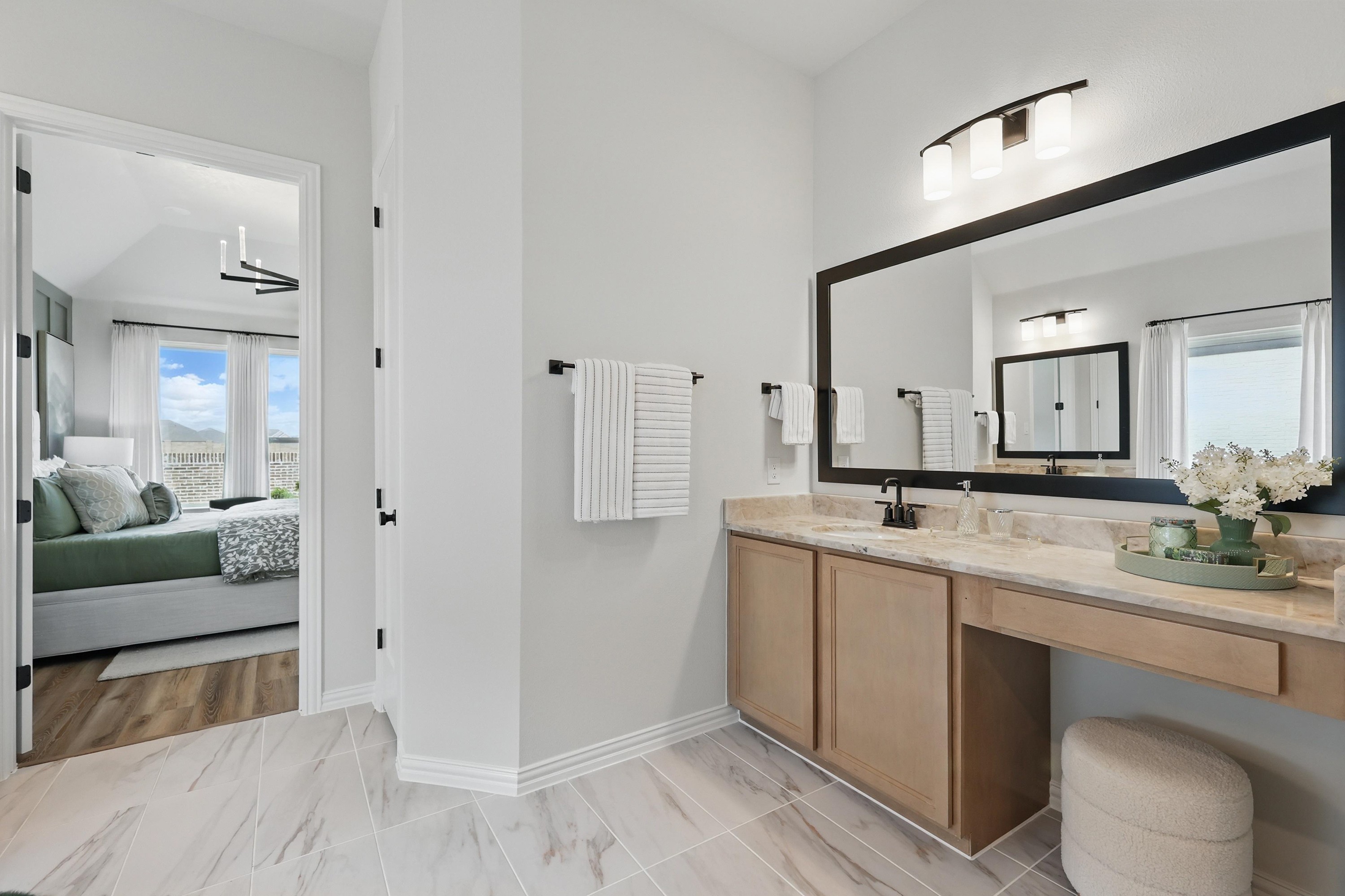 Luxurious Bathroom Vanity with Marble Countertop in Westridge Home Elegant bathroom vanity with marble countertop, large mirror, and natural light in Westridge community.