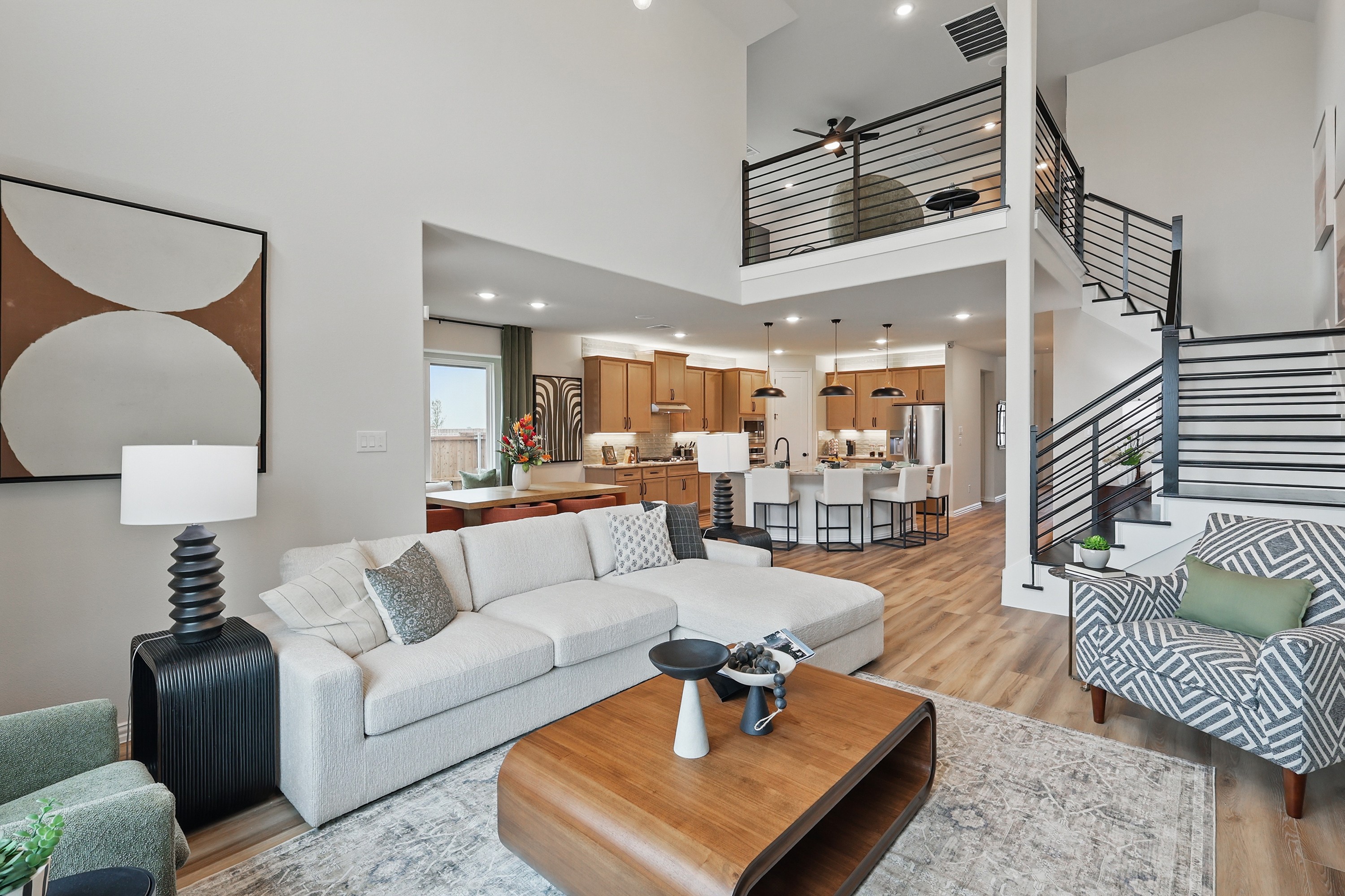 Modern Living Room with Loft and Sleek Staircase in Westridge Modern living room in Westridge with open layout, gray couch, stylish decor, wood floors, loft, sleek staircase.