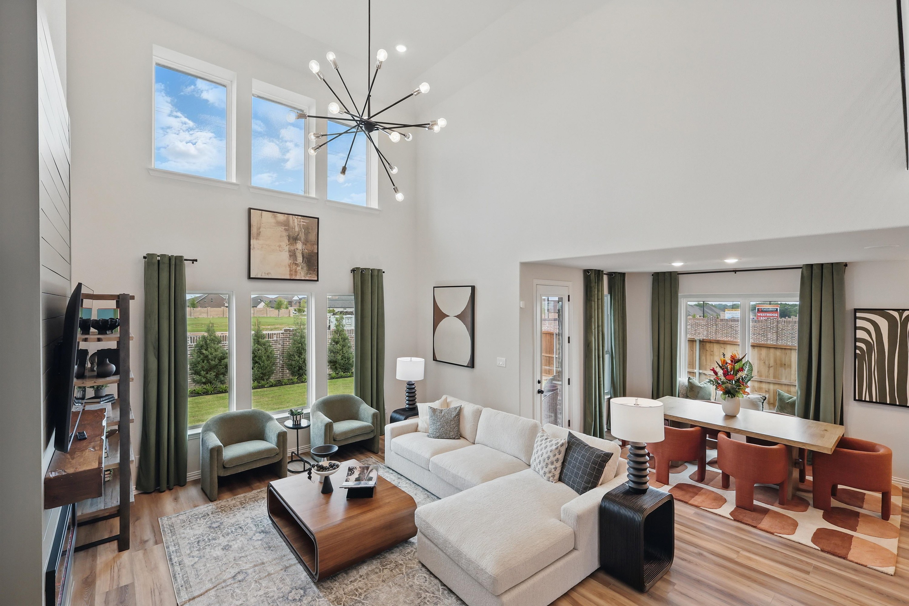 Modern Living Room with High Ceilings in Westridge Community Spacious living room with high ceilings, modern chandelier, large windows, and garden view in Westridge community.