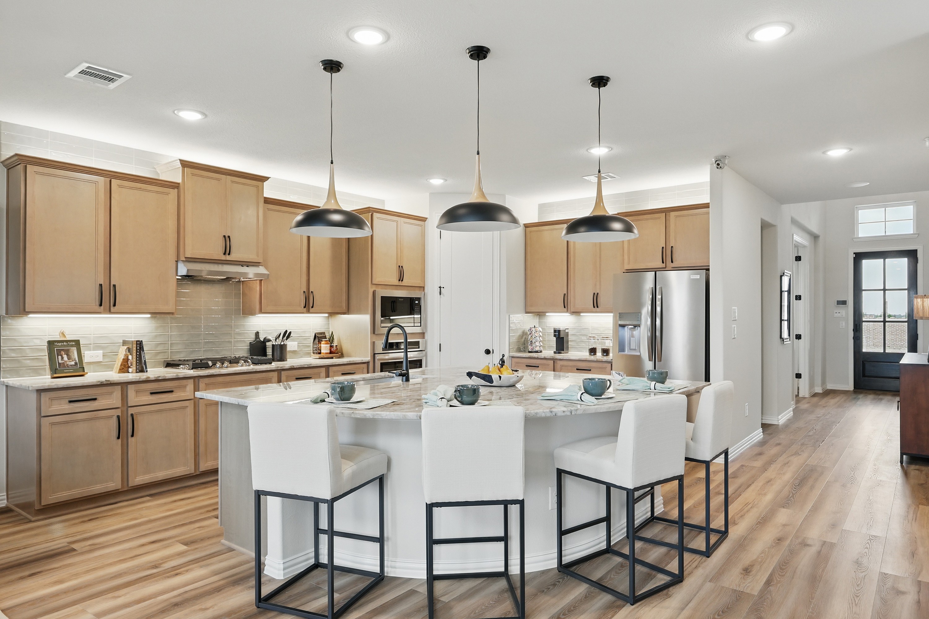 Modern Kitchen Design with Marble Island in Westridge Community Modern kitchen with lightwood cabinets, marble island, pendant lights in Westridge community.