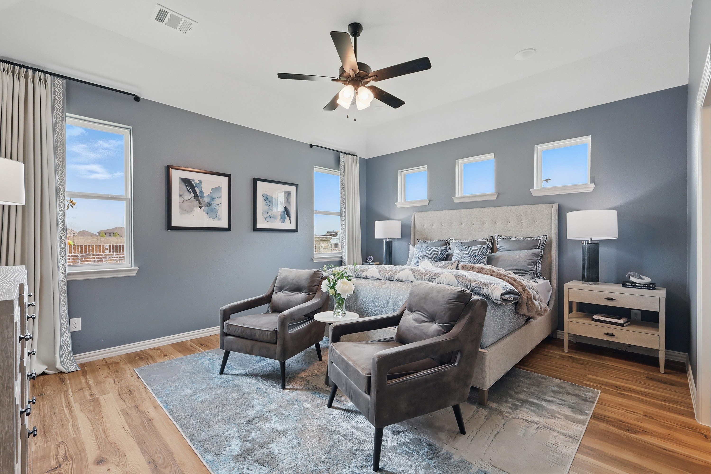 Luxurious Bedroom Design in Westridge Community with Modern Decor Elegant bedroom with gray walls, large windows, modern decor, and wood flooring in Westridge community.