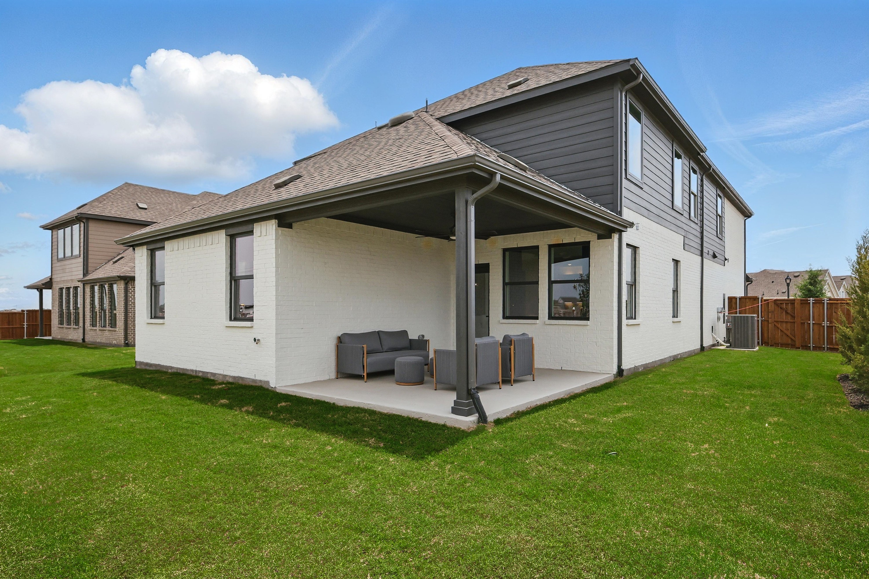 Contemporary Two-Story Home with Patio - Westridge, Texas Real Estate Modern two-story house with covered patio, brick facade, and manicured lawn in Westridge community, Texas.