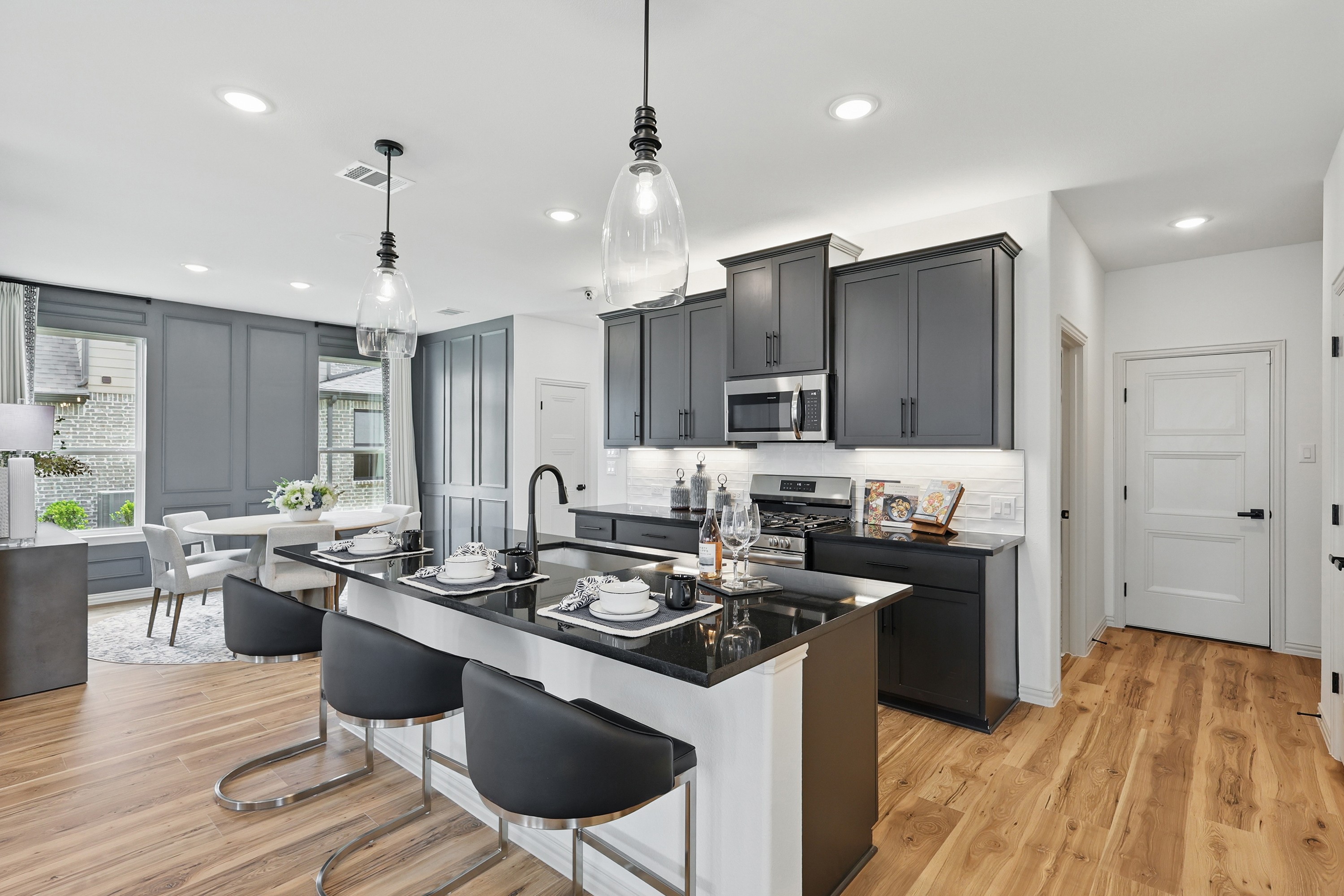 Elegant Kitchen with Black Cabinets in Westridge Home Modern kitchen with black cabinets, island seating, and wood floors in Westridge community home.