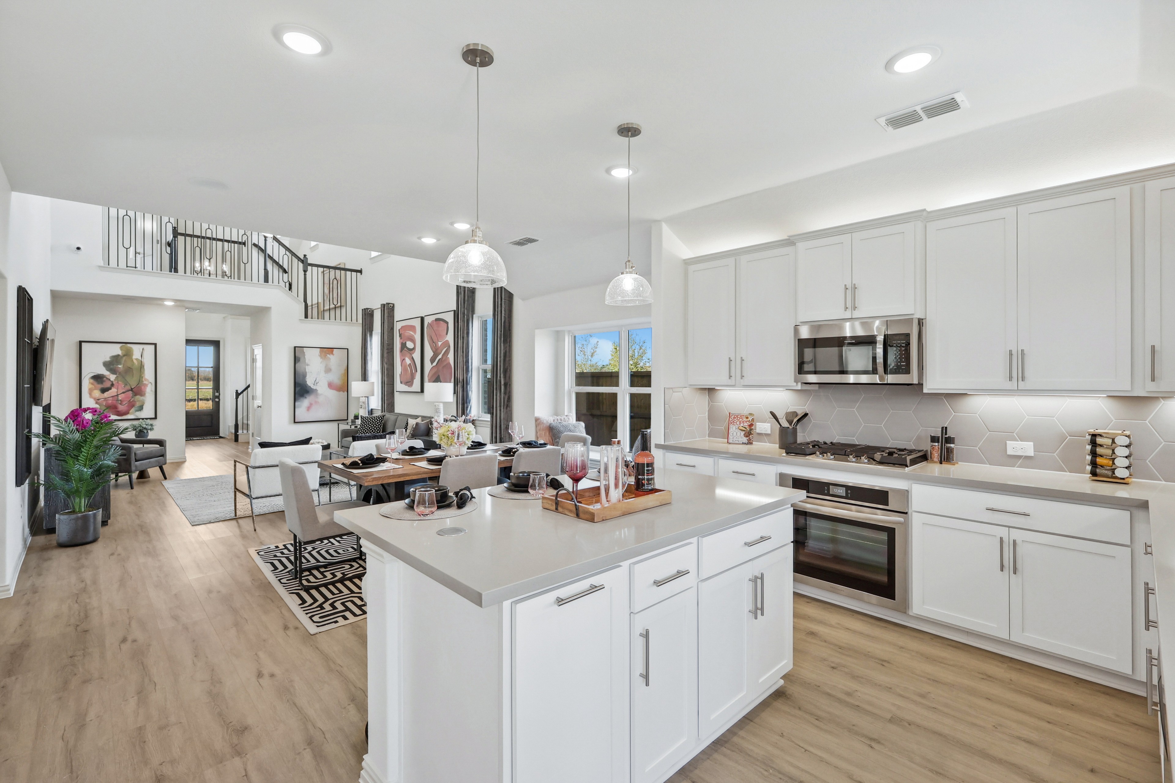 Modern Kitchen in Bel Air Village with Open Layout and Stylish Design Elegant Bel Air Village kitchen with white cabinetry, pendant lights, wood flooring, open layout, dining area view.
