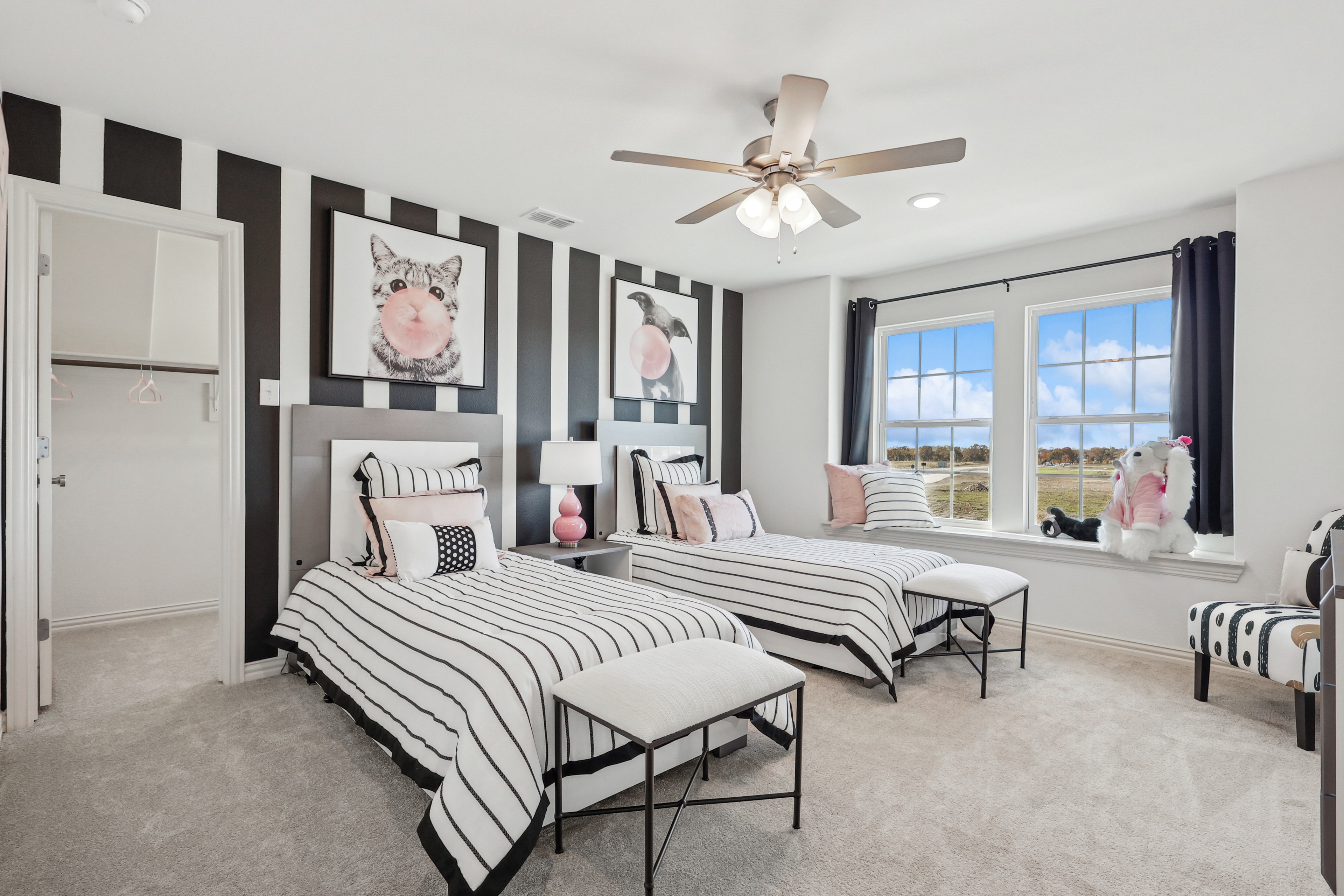 Elegant Twin Bedroom Decor with Stripes in Bel Air Village Stylish twin bedroom with striped decor, playful artwork, and expansive windows in Bel Air Village community.