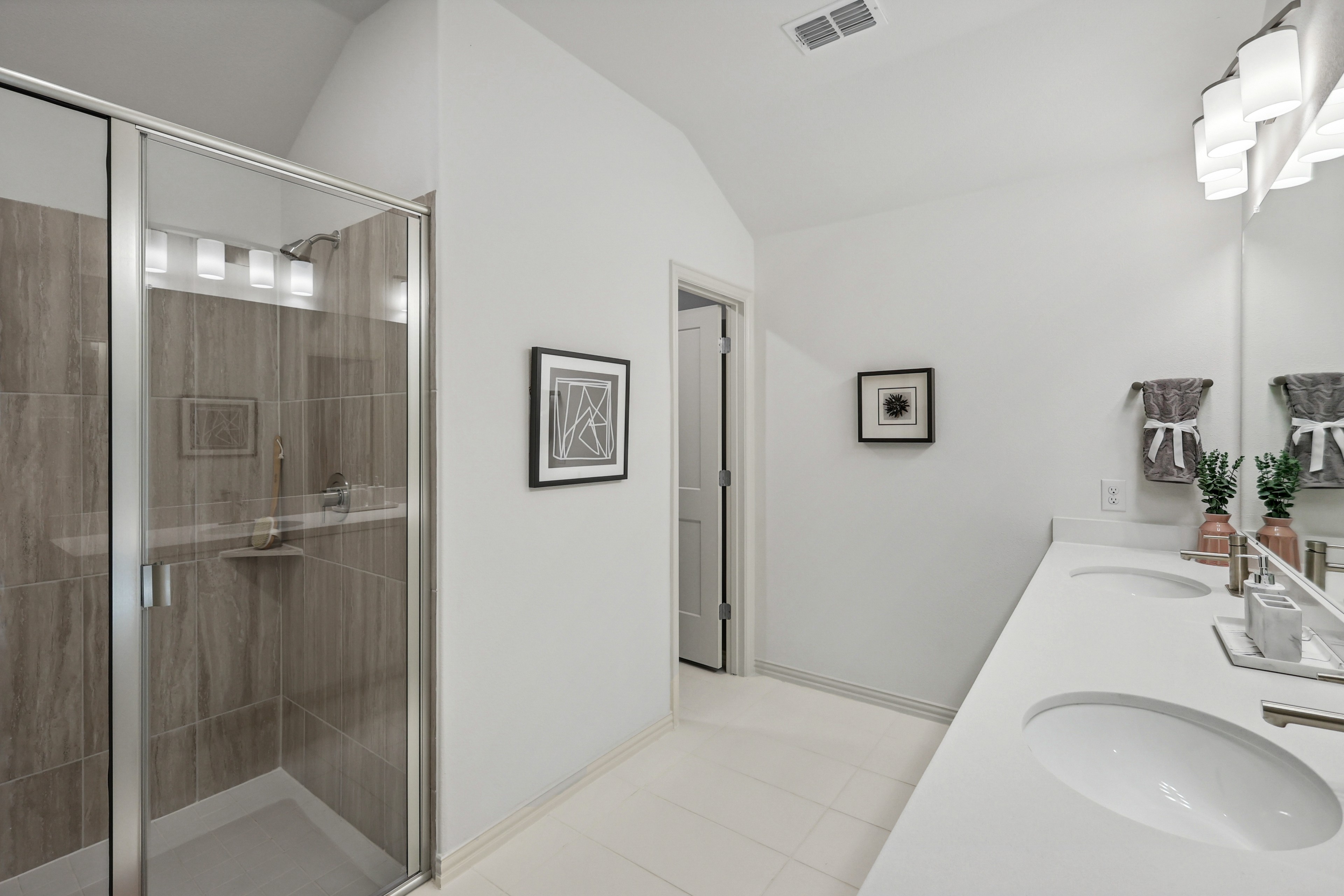 Luxurious Bathroom with Double Vanity in Bel Air Village Modern bathroom with double sink vanity, frameless glass shower, in Bel Air Village. Minimalist decor, bright lighting.