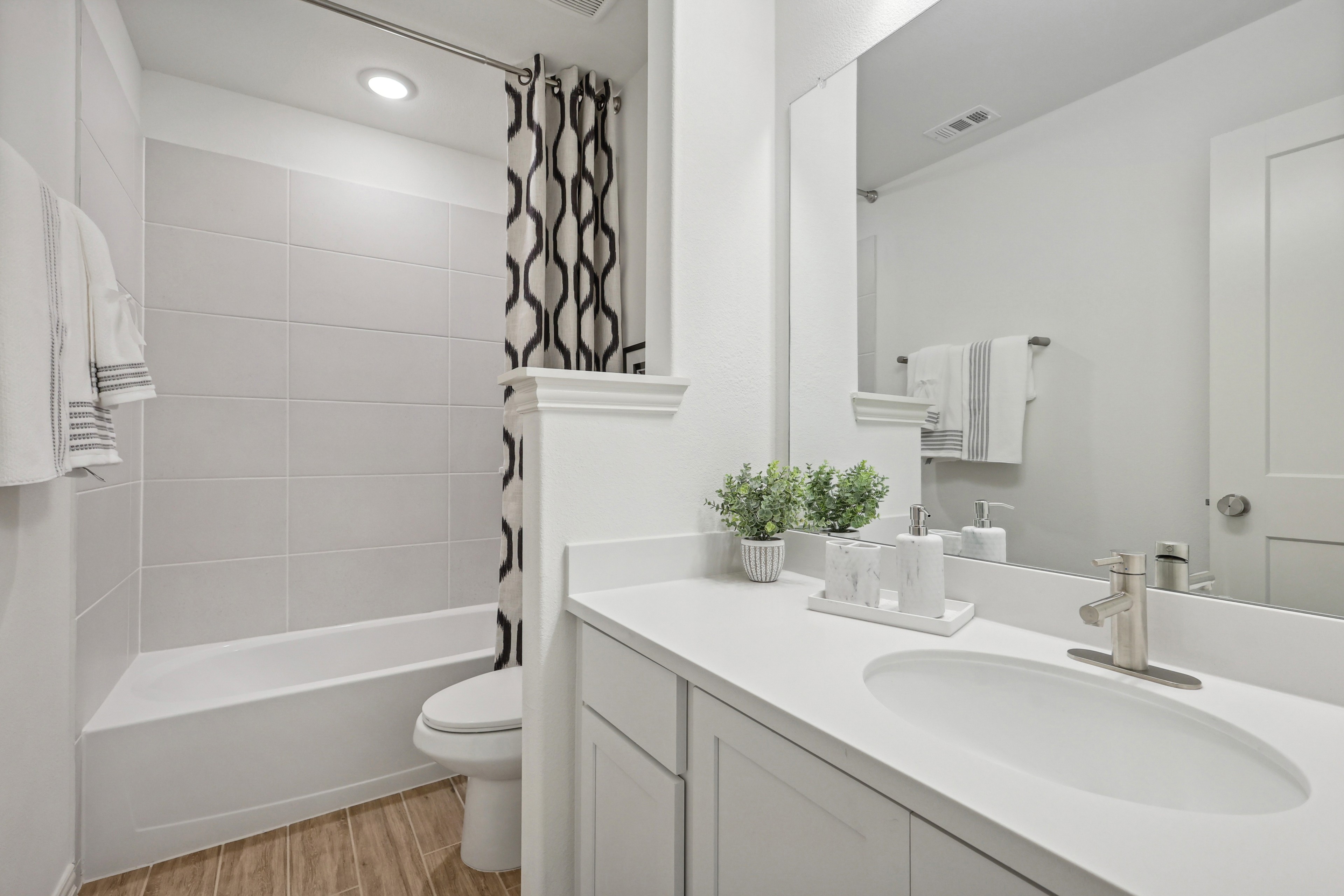 Modern Bathroom with White Vanity and Tile, Bel Air Village Modern bathroom with white vanity, oval sink, chrome faucet, large mirror, and stone-inspired tile in Bel Air Village.