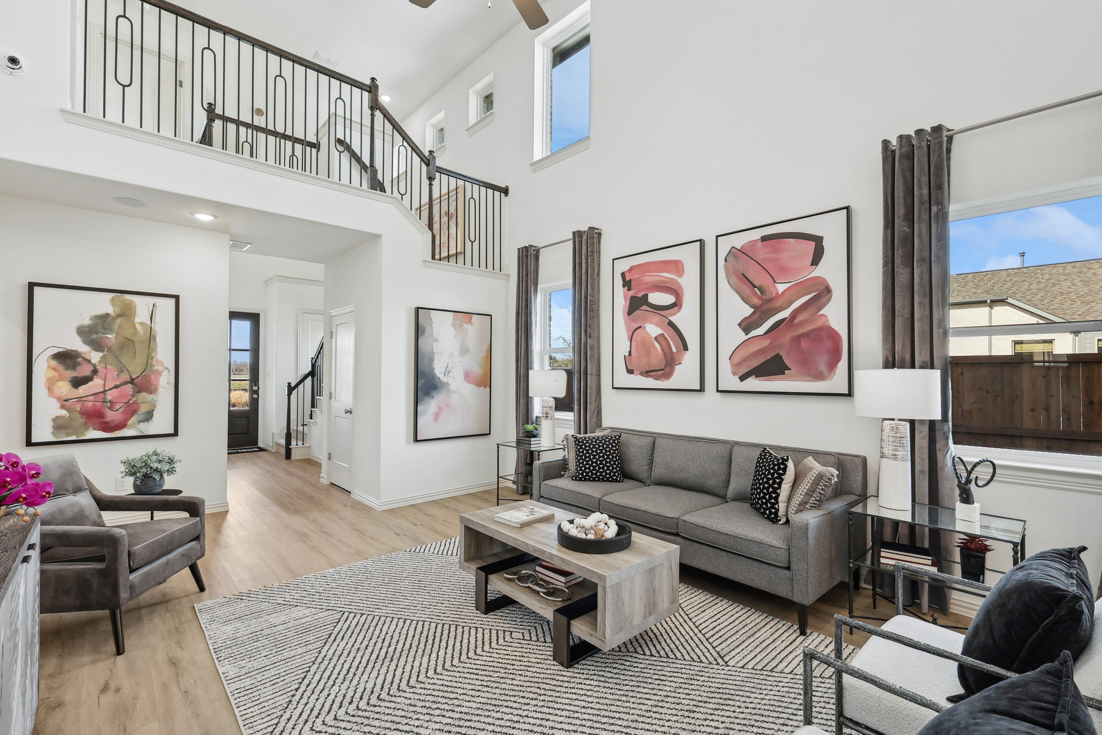 Modern Living Room with High Ceilings and Art in Bel Air Village Spacious living room with modern art, high ceilings, elegant railing, and large windows in Bel Air Village.