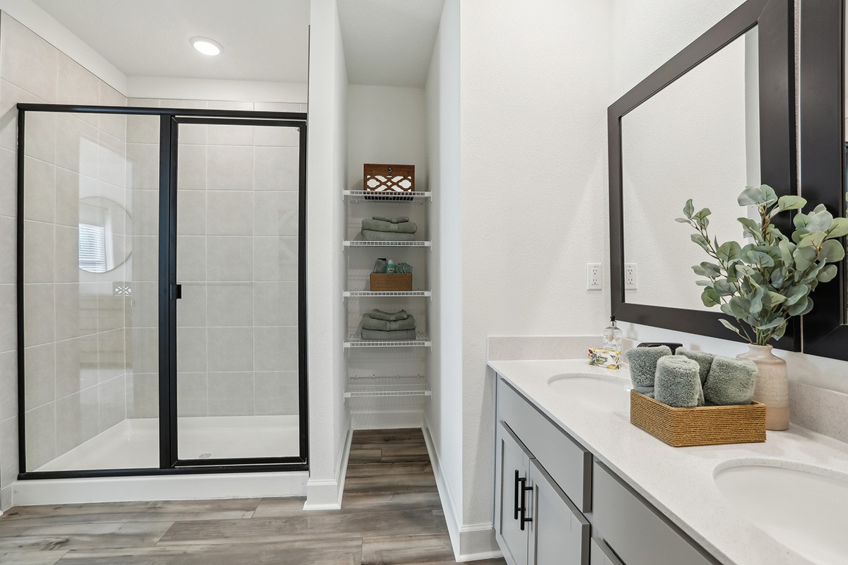 Spring Hill Modern Bathroom with Glass Shower and Vanity Modern Spring Hill bathroom featuring glass shower, shelving, vanity, and wood flooring.