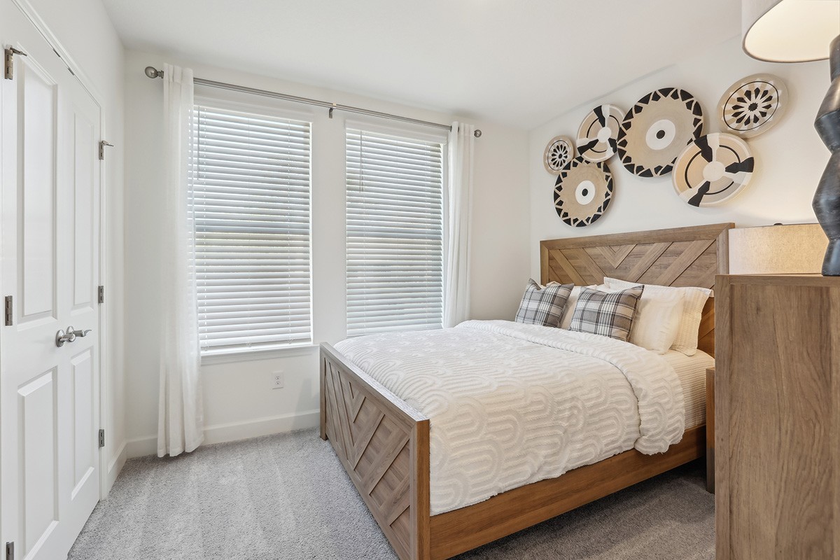 Modern Bedroom with Geometric Wood Bed in Spring Hill Modern bedroom with geometric wood bed, decorative wall plates, and large windows in Spring Hill.