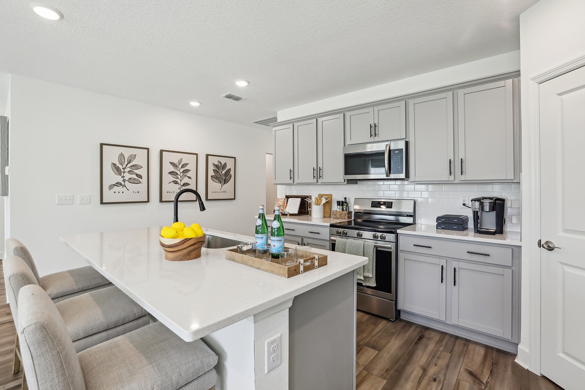 Elegant Gray Cabinet Kitchen with Island in Spring Hill Modern kitchen with gray cabinets, white subway tile backsplash, and island in Spring Hill.