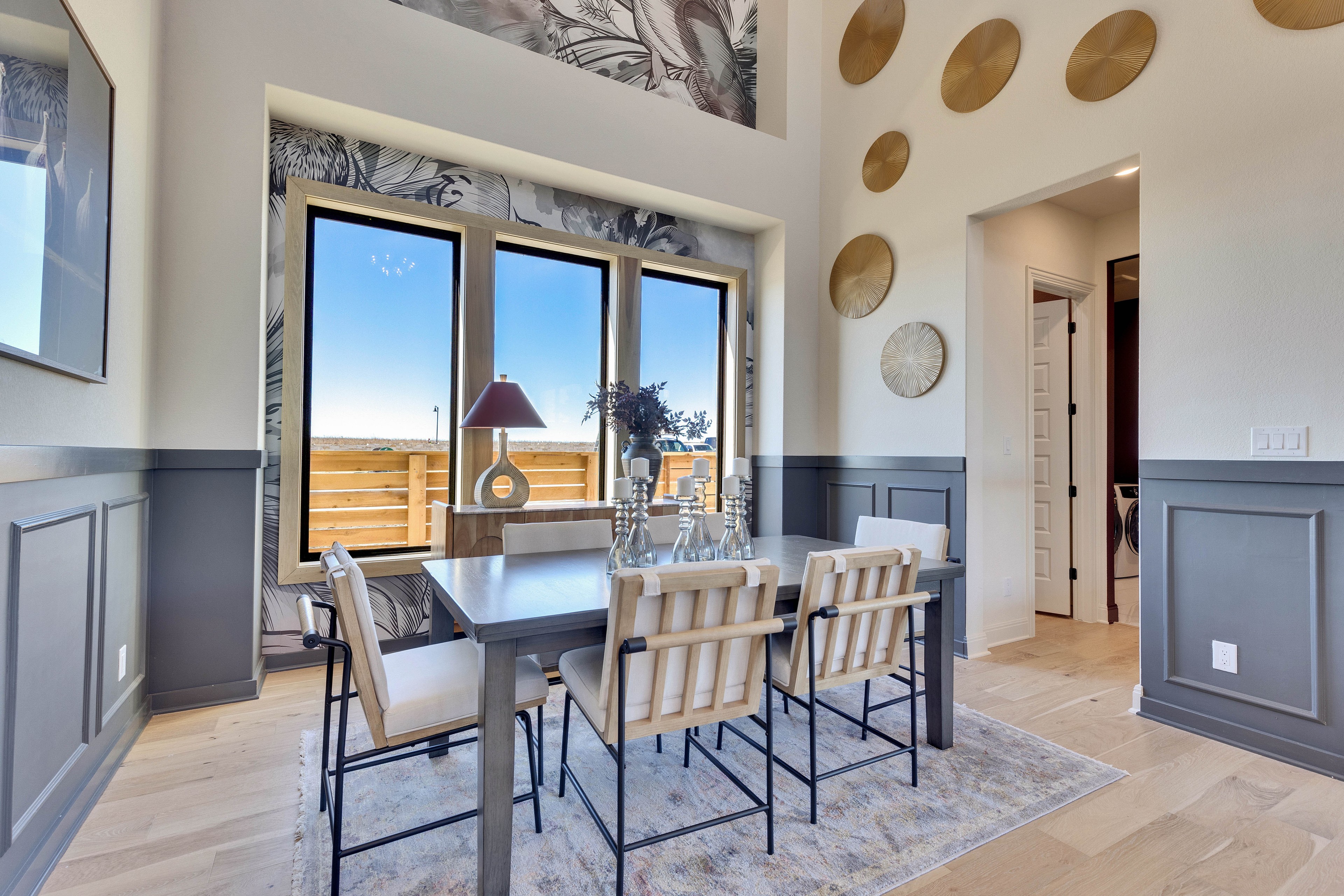 Modern Dining Room with Large Windows in Flora Community Modern dining room with large windows, artistic wall decor, and wainscoting in Flora community.