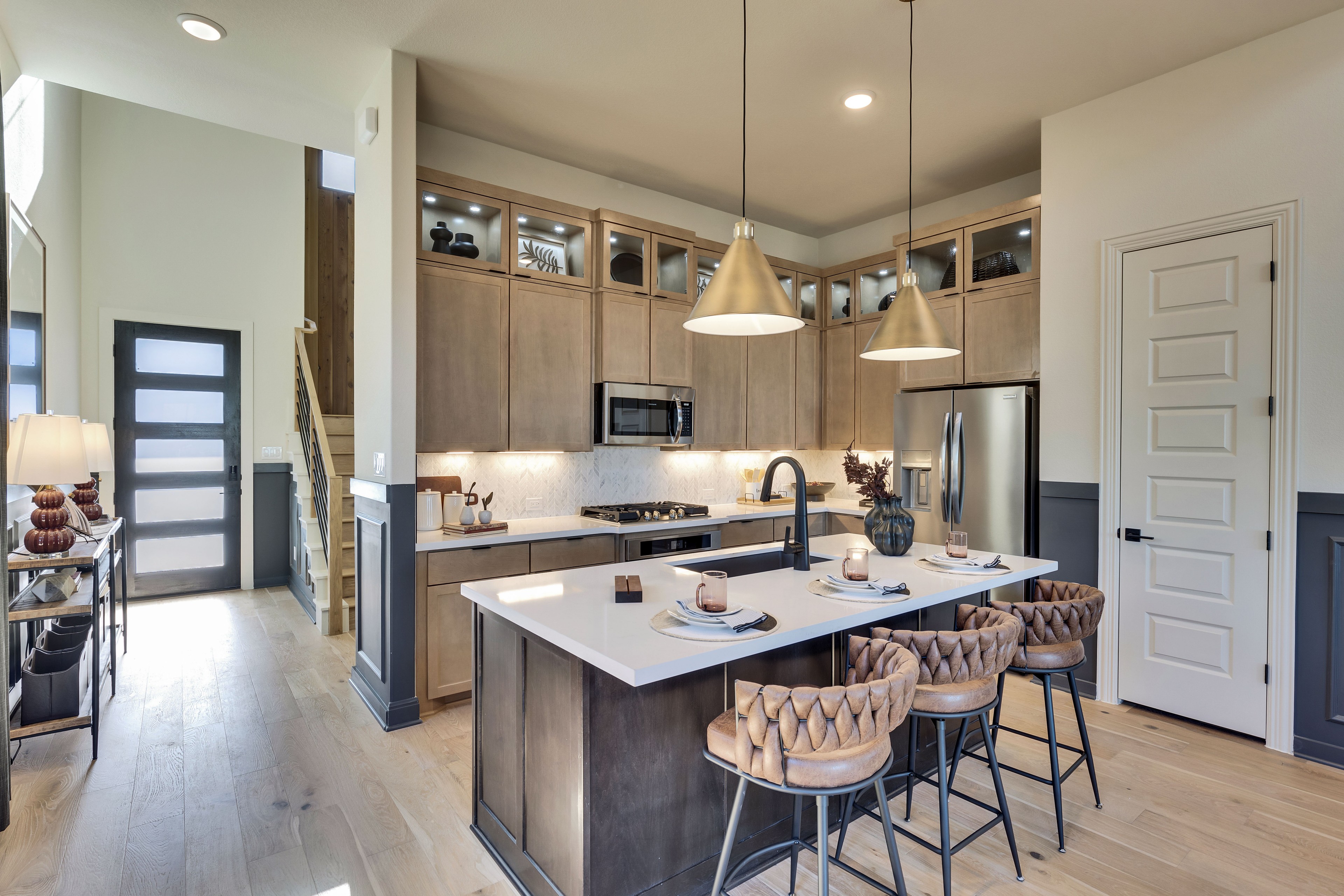 Luxury Kitchen Design in Flora Community, Texas Modern kitchen in Flora community with island, pendant lights, and wooden cabinetry. Texas home luxury interior.