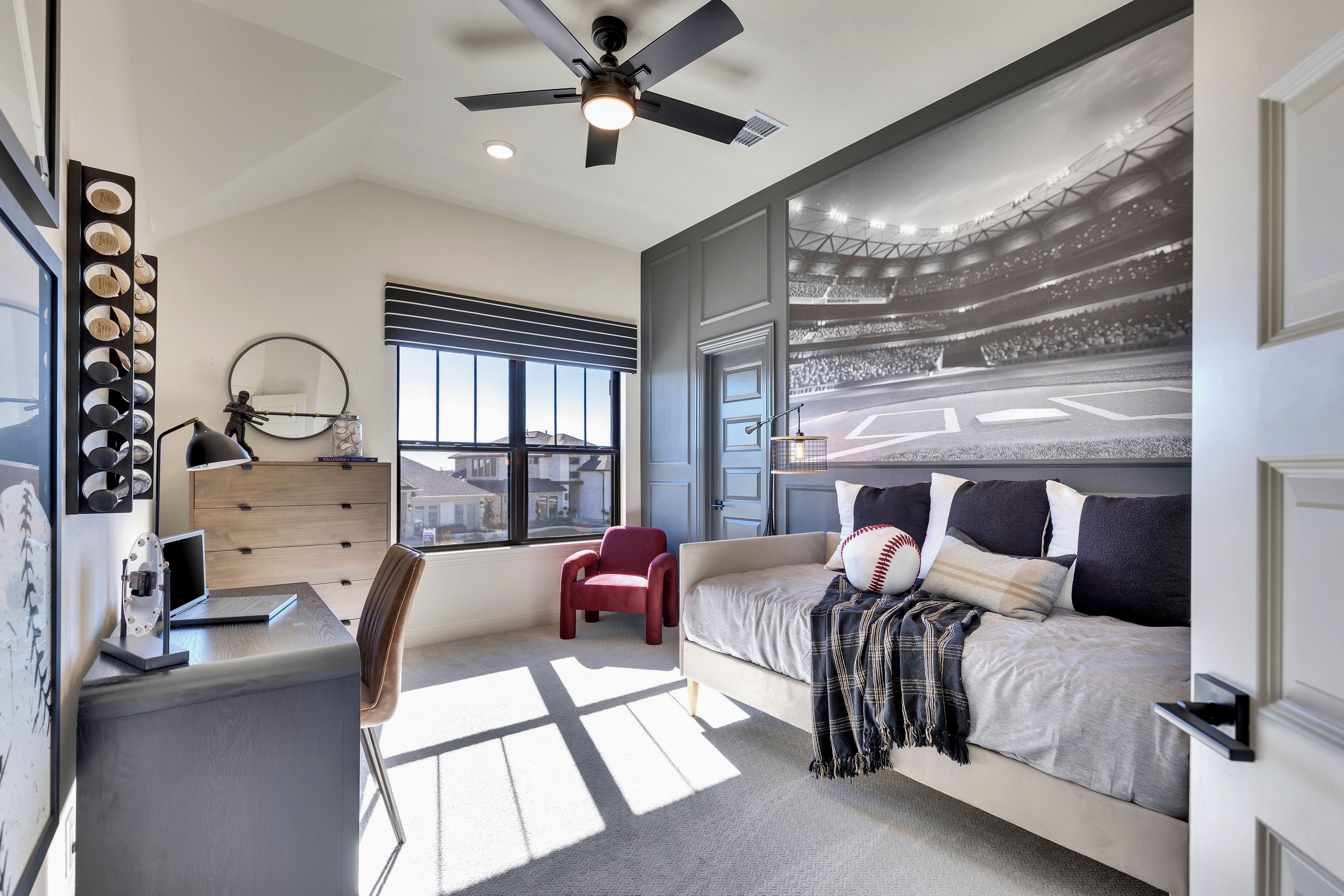 Stylish Bedroom with Baseball Theme in Flora Community Modern bedroom with baseball mural, cozy seating, desk, and large window in Flora community.