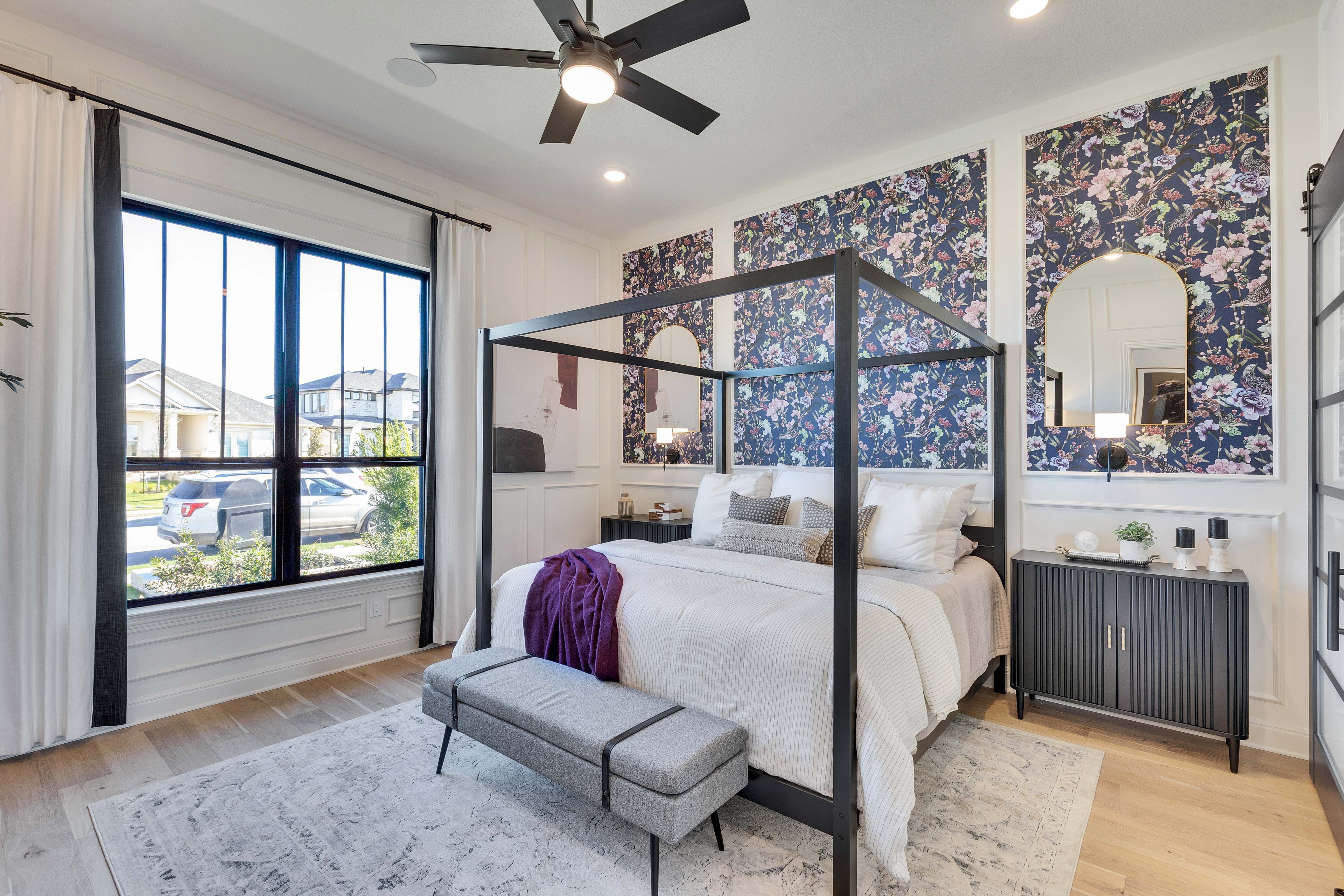 Flora Community Bedroom with Floral Accent Walls and Hardwood Floors Elegant bedroom with floral accent wall and canopy bed, featuring hardwood floors. Located in Flora community.