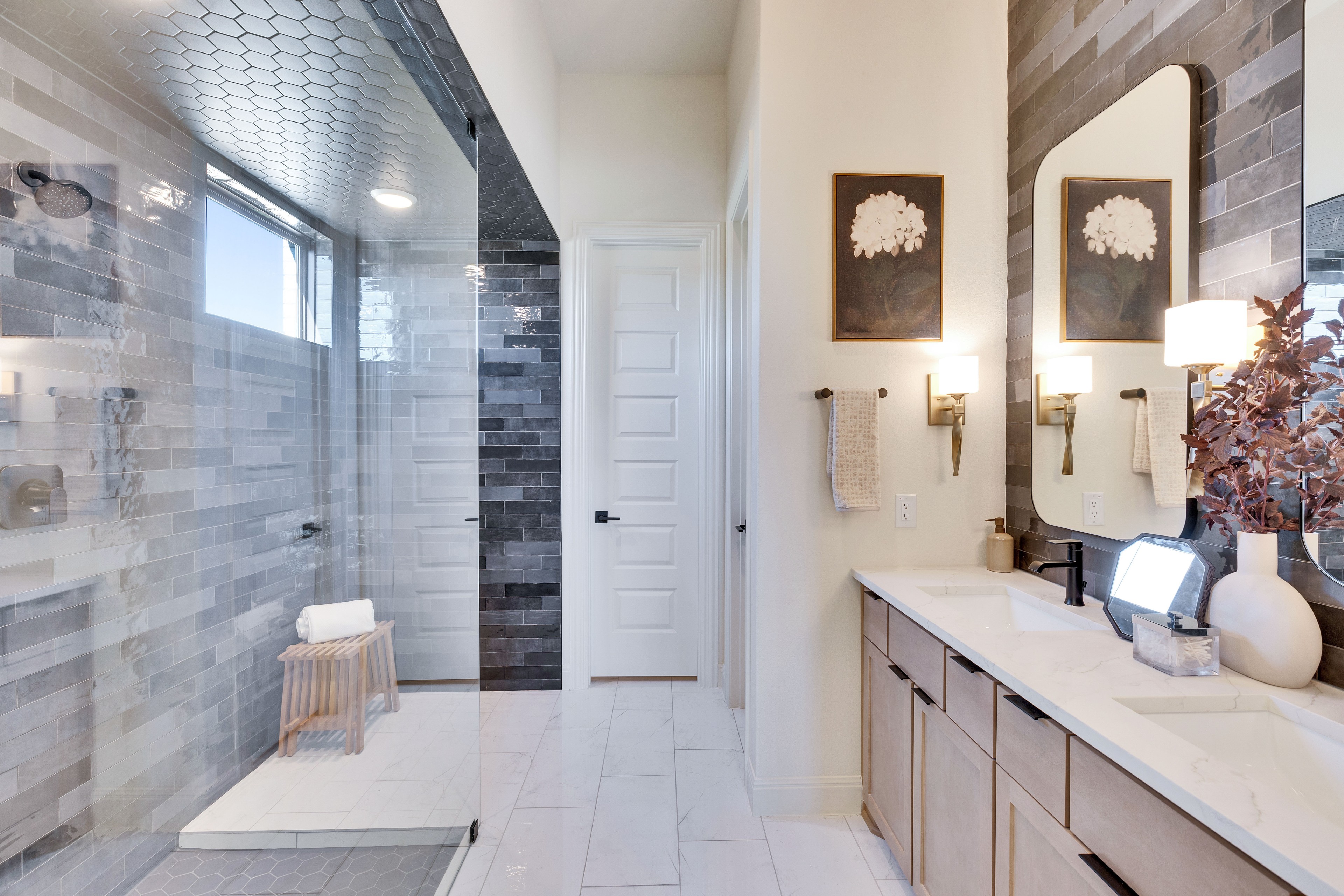 Luxurious Flora Community Bathroom with Marble Countertops and Glass Shower Luxurious bathroom in Flora community, featuring marble countertops, hexagonal tile ceiling, and spacious glass shower.