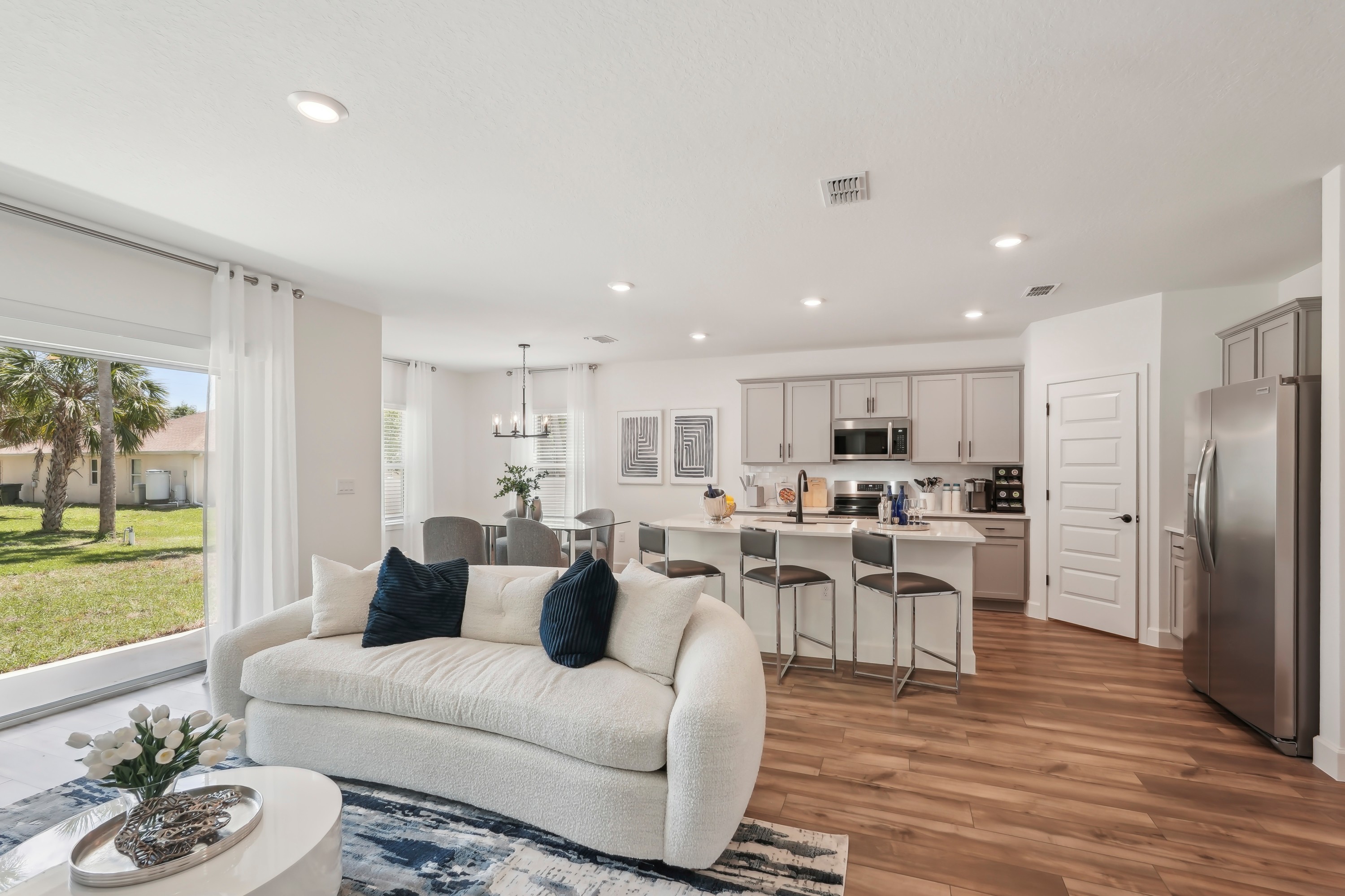 Open-Plan Kitchen and Living Room in North Port Home Modern North Port open-plan kitchen with gray cabinetry, hardwood floors, and cozy living area.