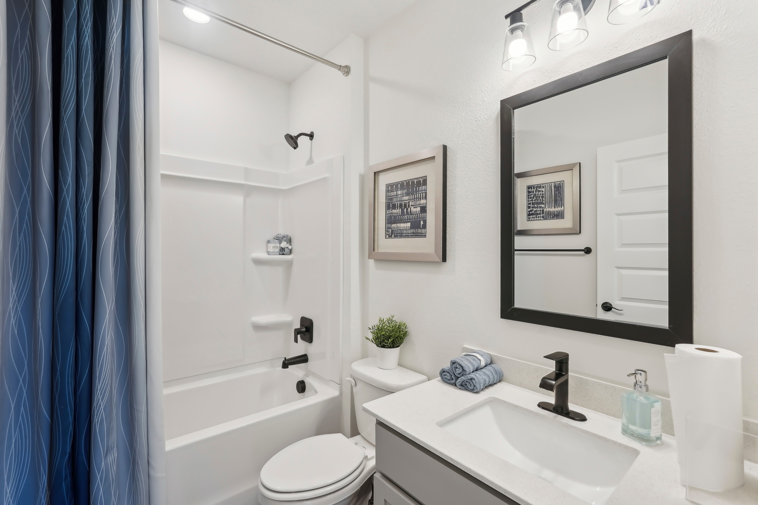 North Port Bathroom with Black Fixtures and Modern Design Modern North Port bathroom with black fixtures, framed mirror, and white vanity.