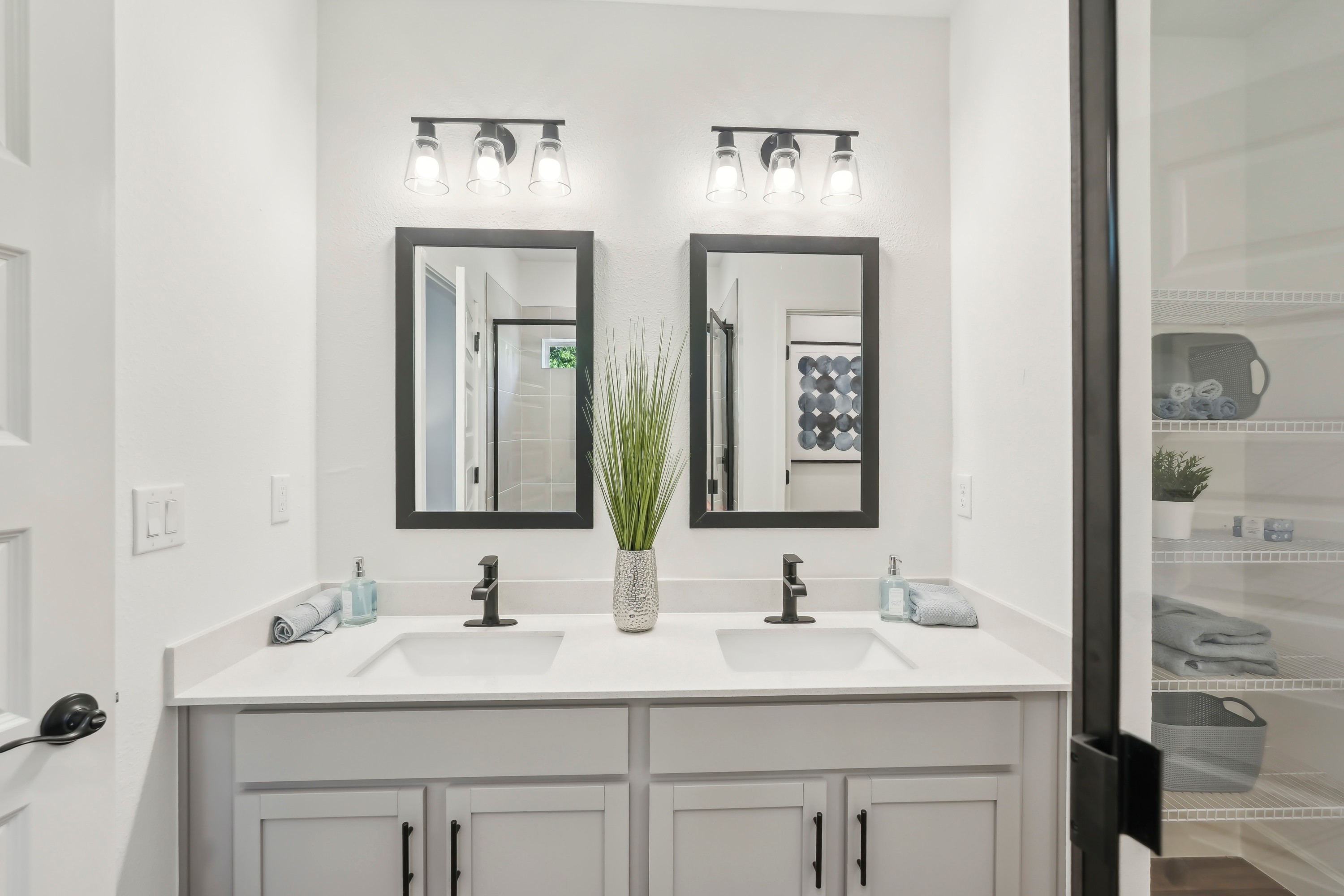 Double Vanity Bathroom in North Port Home Modern double vanity with black-framed mirrors and sleek faucets in North Port home bathroom.
