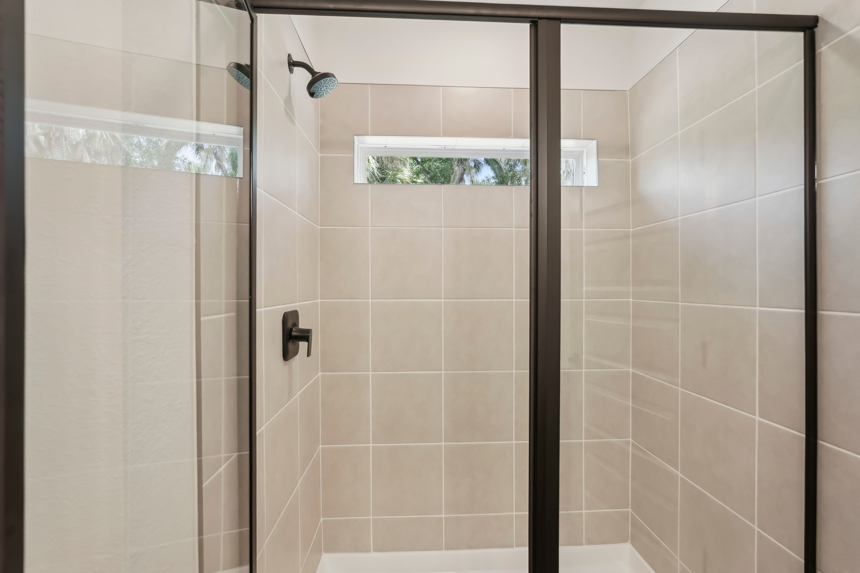 Modern Shower with Glass Door in North Port Home Modern shower with glass door, tiled walls, and sleek fixtures in North Port home.
