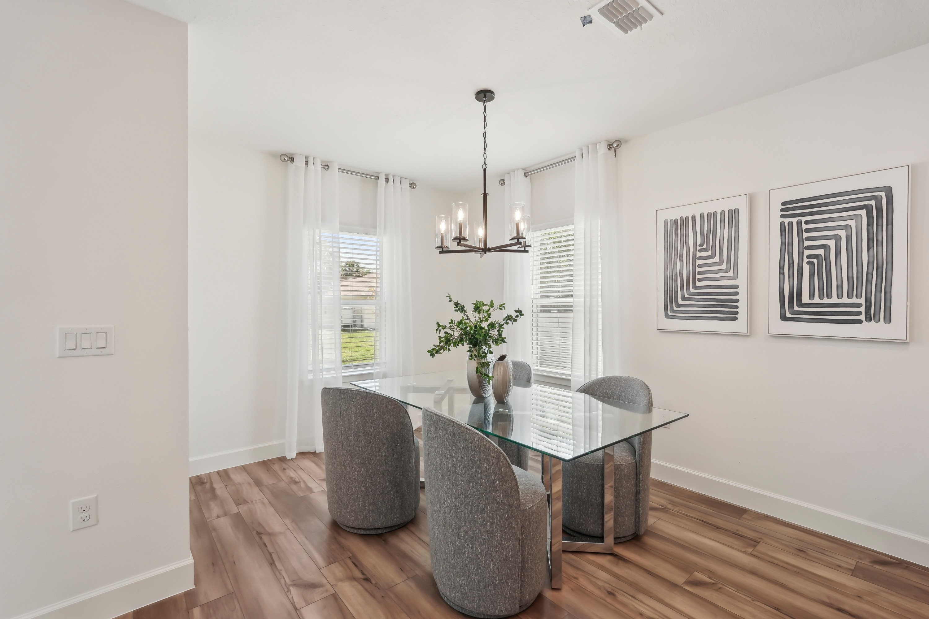 North Port Dining Room with Glass Table and Modern Decor Modern dining room with glass table, wooden floor, elegant lighting in North Port.