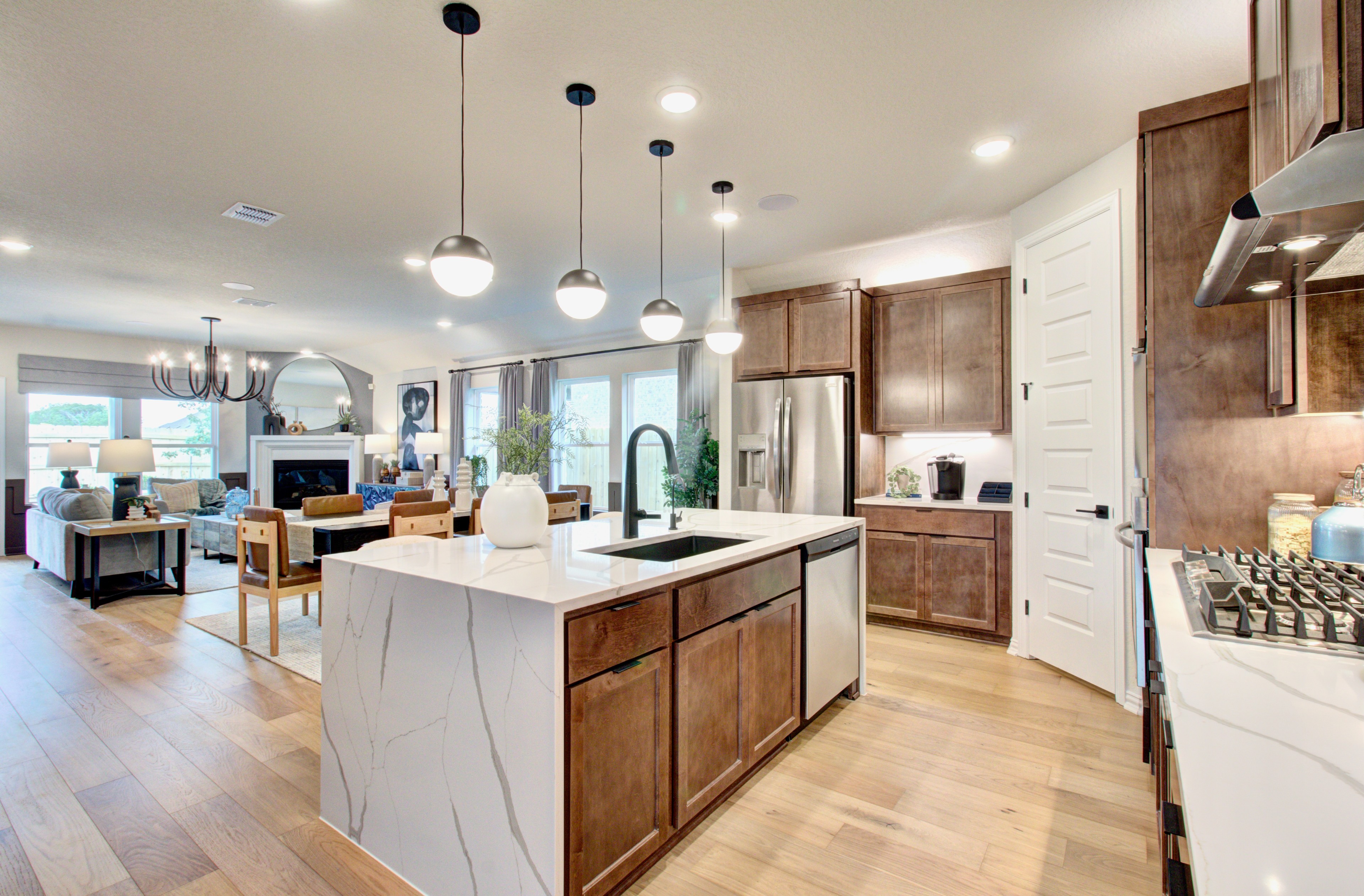Elegant Modern Kitchen in Sunflower Ridge with Marble Island Modern kitchen with marble island, wooden cabinets, pendant lighting in Sunflower Ridge, showcasing open-concept design.