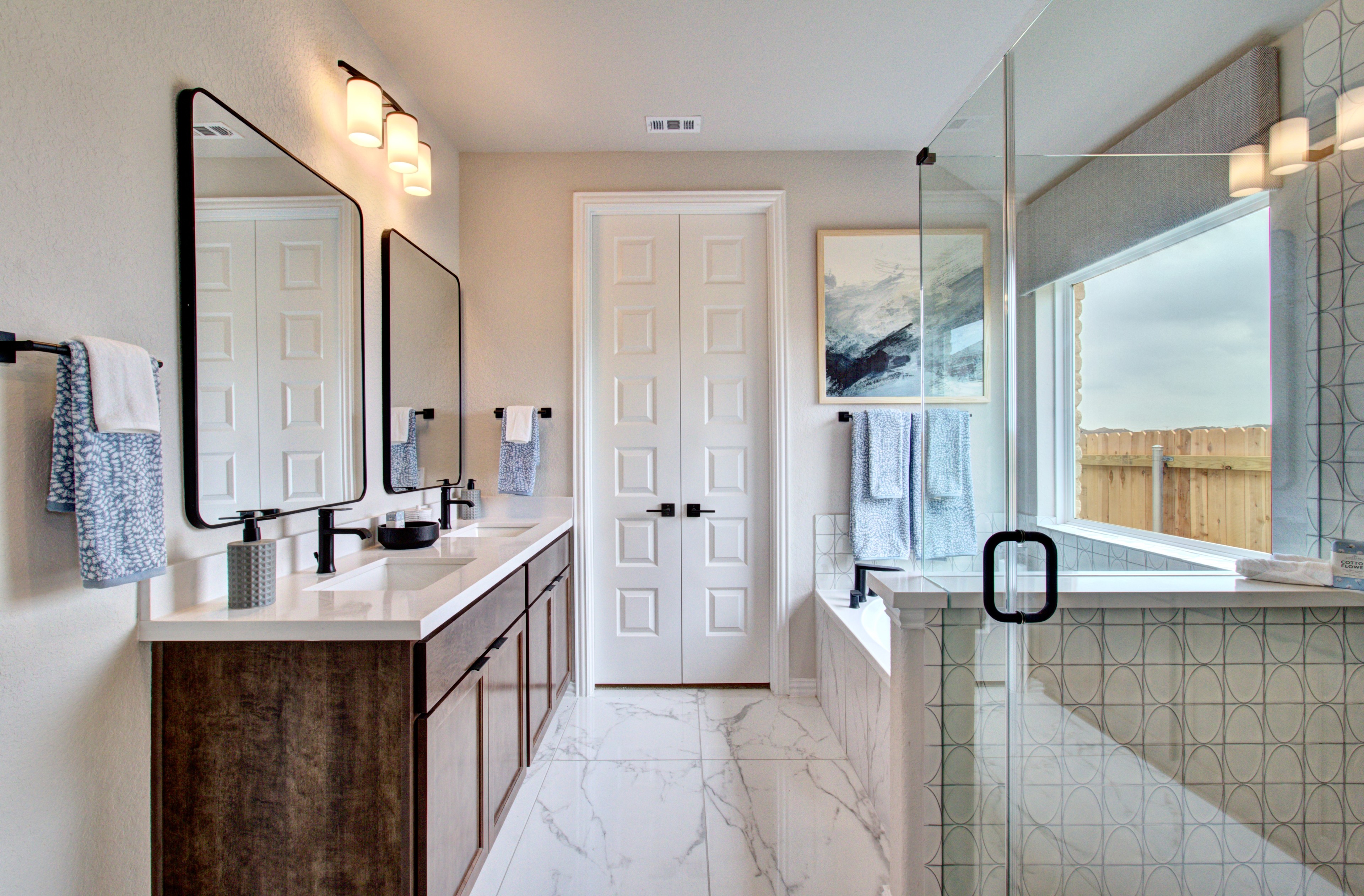 Elegant Bathroom Design with Dual Vanity in Sunflower Ridge Modern bathroom with dual vanity, frameless glass shower, marble tiles in Sunflower Ridge community.
