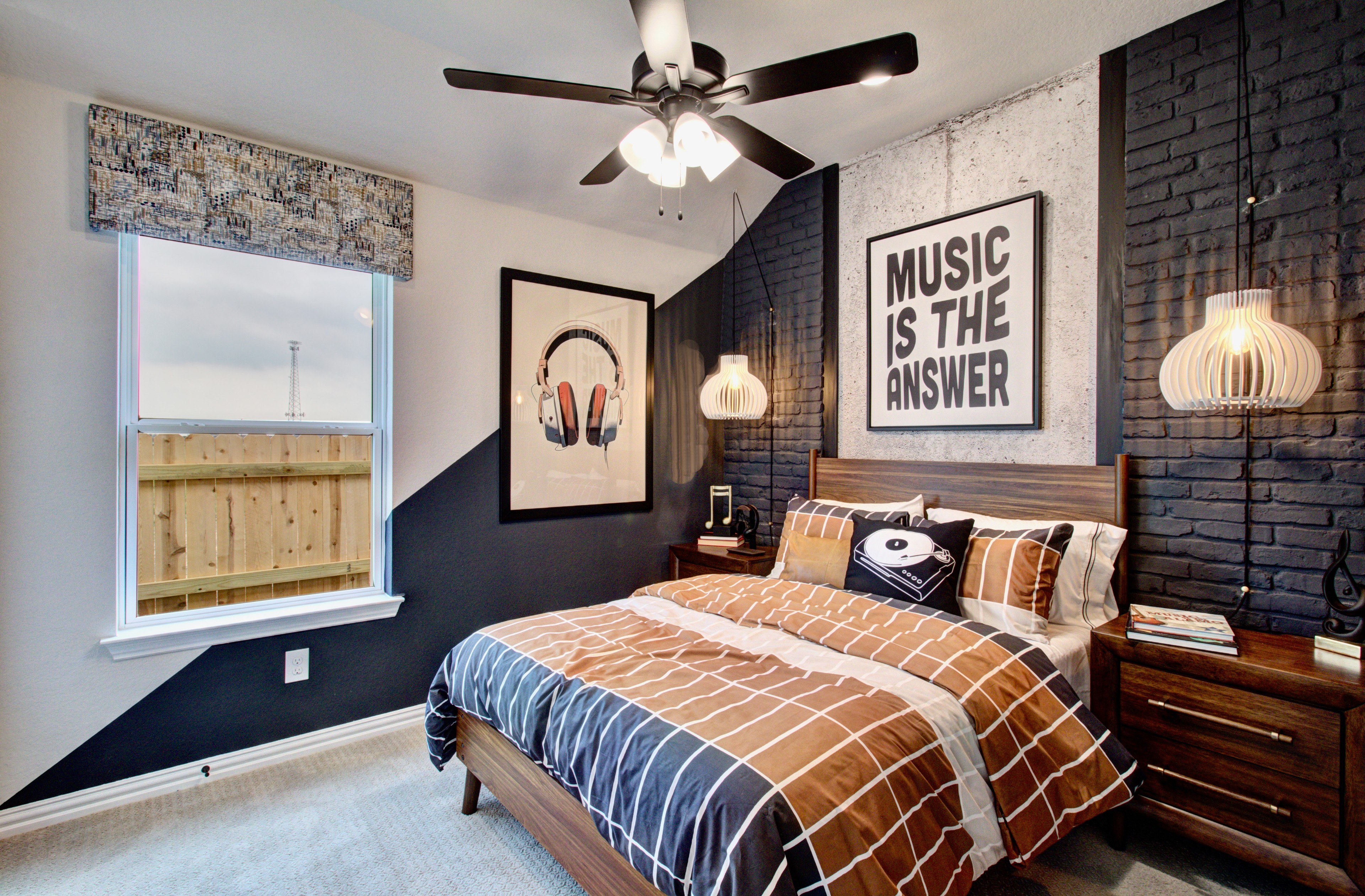 Music-Themed Modern Bedroom at Sunflower Ridge Modern bedroom at Sunflower Ridge with music-themed decor, black brick accent wall, ceiling fan, bedside lighting.