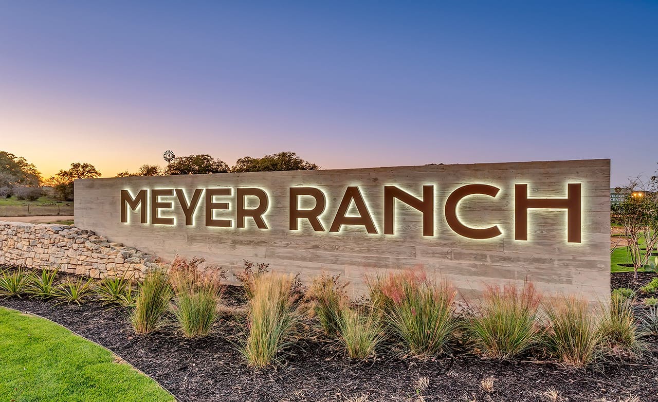 Meyer Ranch Illuminated Sign at Sunset in Texas Hill Country Illuminated Meyer Ranch sign at sunset with lush landscaping in Texas hill country.