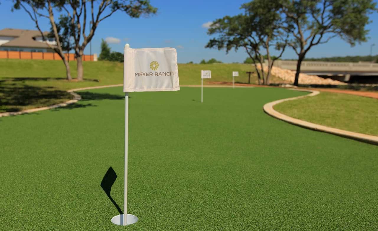 Meyer Ranch Putting Green in Luxury Enclave Community Putting green with Meyer Ranch flag, surrounded by manicured lawns, trees, in a luxury enclave community.