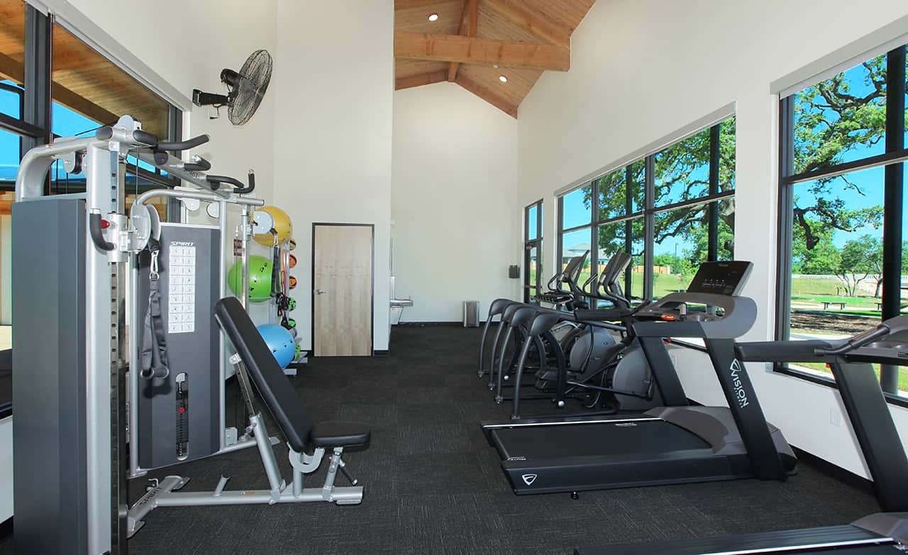 Meyer Ranch Enclave Gym with Vaulted Ceilings and Views Modern fitness center with cardio machines and weights, vaulted wood ceiling, large windows. Meyer Ranch Enclave.