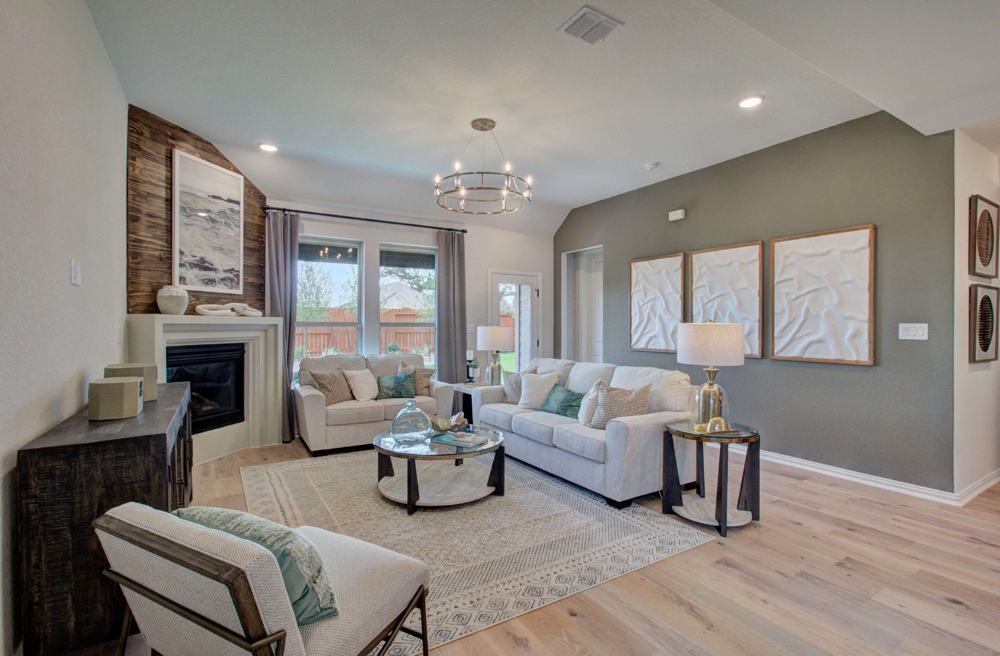 Upscale Meyer Ranch Living Room with Fireplace and Modern Design Elegant living room with gray walls, modern chandelier, fireplace, large windows in Meyer Ranch, Enclave community.