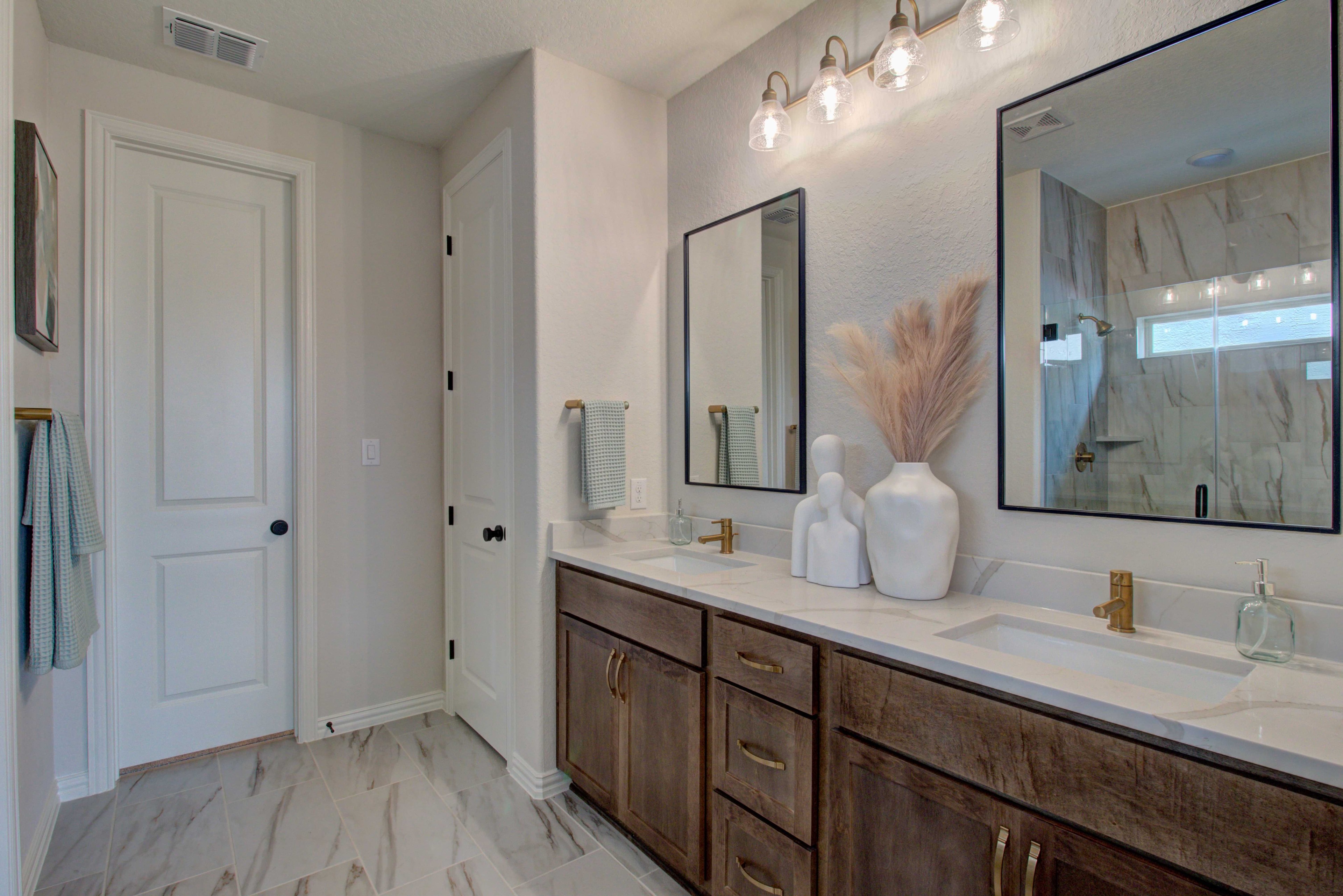 Meyer Ranch Enclave Bathroom with Double Vanity and Gold Fixtures Elegant bathroom with double vanity, gold fixtures, and marble tiles in Meyer Ranch Enclave.