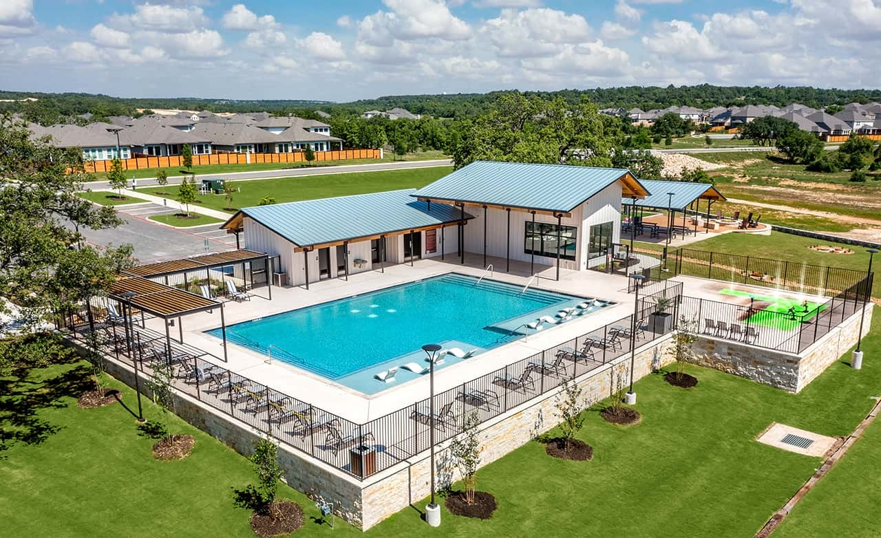 Meyer Ranch Enclave Community Pool Modern Design Modern community pool with stone walls, blue roofs, and ample seating in Meyer Ranch enclave, lush landscape surrounds.