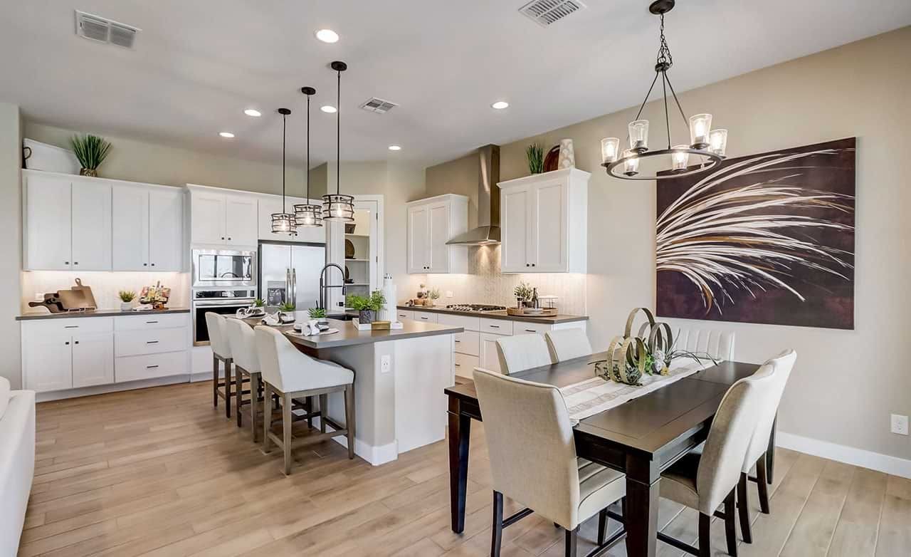 Modern Kitchen with Island Seating in Hacienda Community Spacious kitchen in Hacienda with white cabinets, island seating, pendant lights, and modern art.