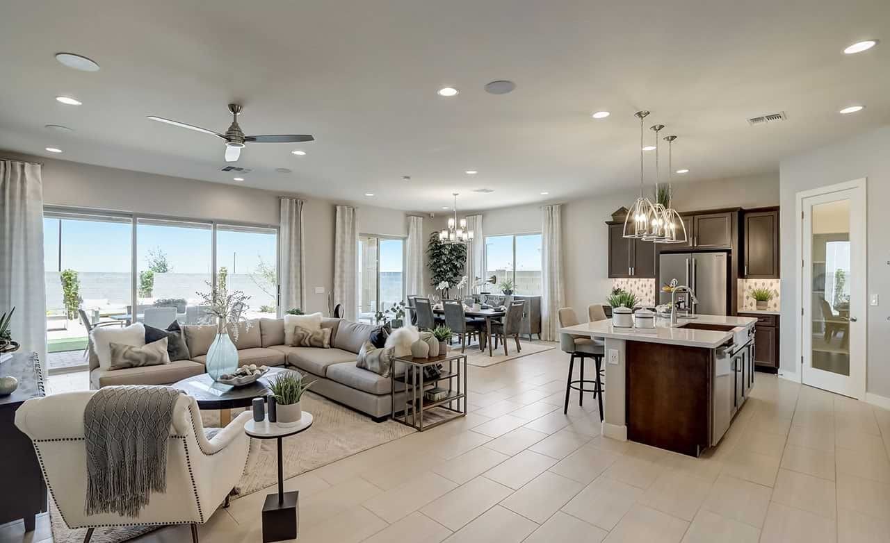 Luxurious Open-Plan Living Space in Hacienda Community, Arizona Spacious open-plan living area with modern kitchen, large sofa, dining table, ceiling fan, Arizona.