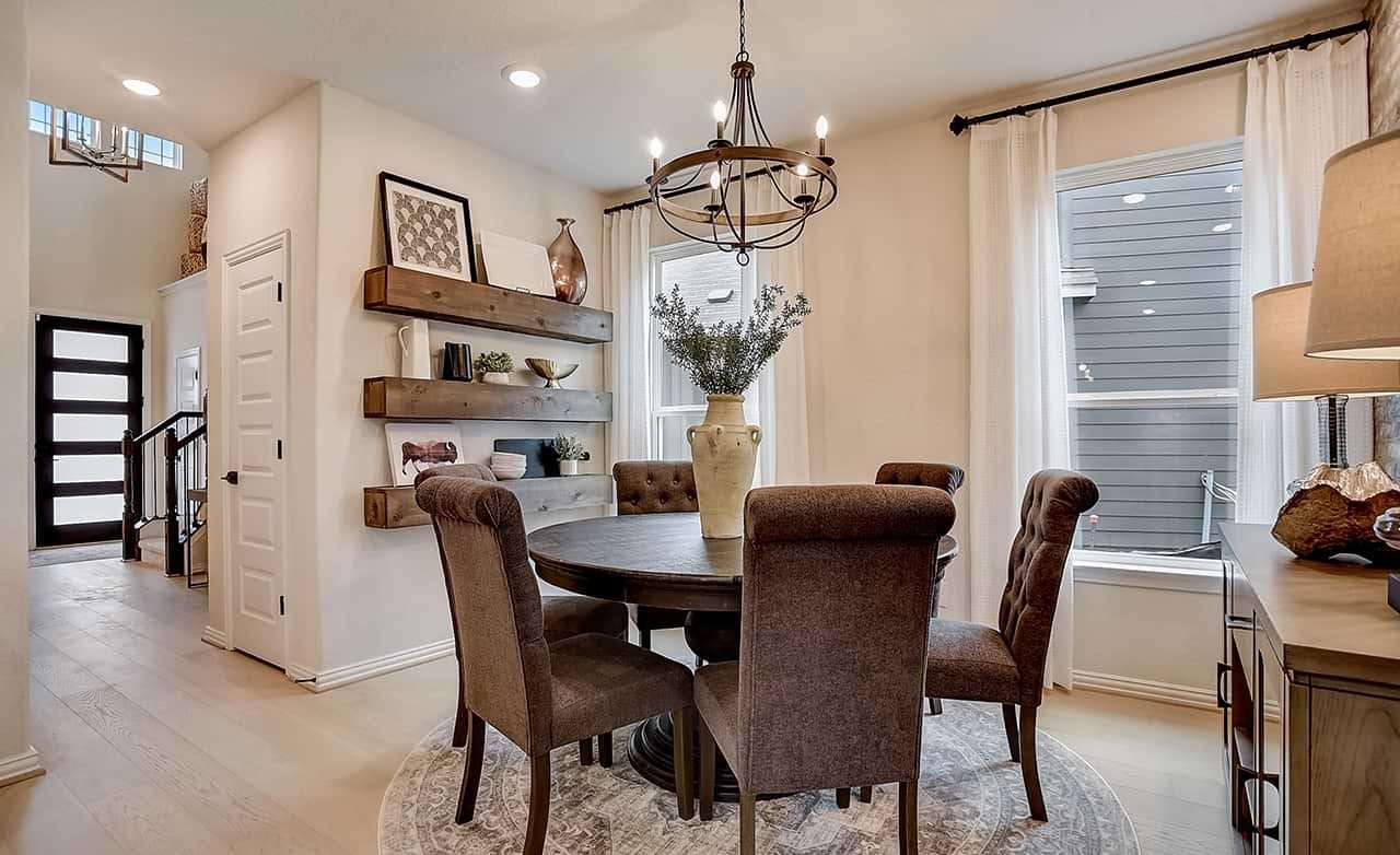 Elegant Dining Room in Casinas at Gruene Community Home Dining room with round table, elegant chandelier, modern shelves, in Casinas at Gruene community's luxury home.