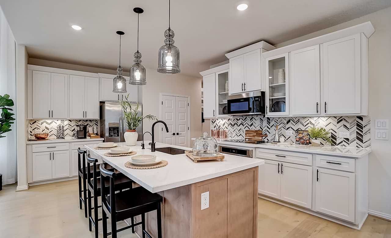 Modern Kitchen Design with Herringbone Backsplash in Casinas at Gruene Modern kitchen with white cabinets, island, herringbone backsplash, pendant lighting, Casinas at Gruene.