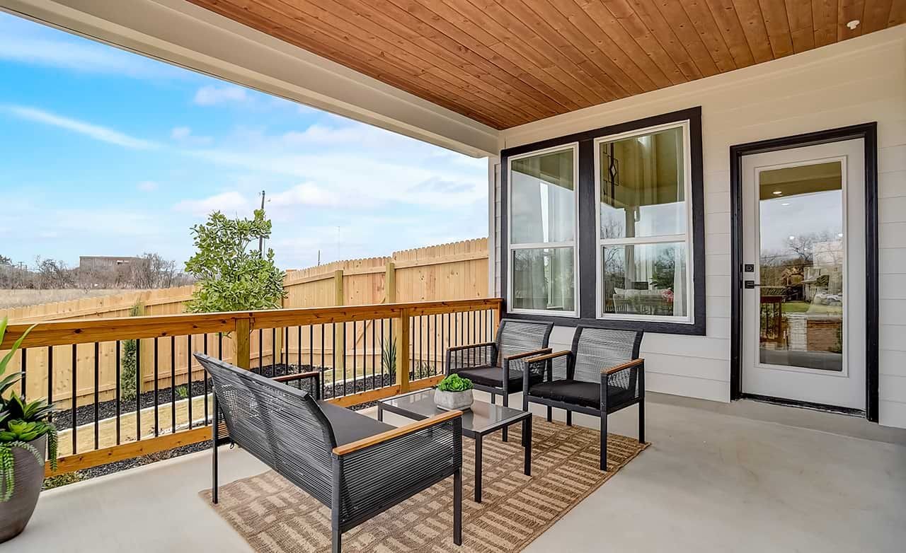 Modern Patio with Wood Ceiling in Gruene, Texas Community Modern patio with elegant chairs, wooden ceiling, and glass door in Gruene community, Texas. Fenced yard view.