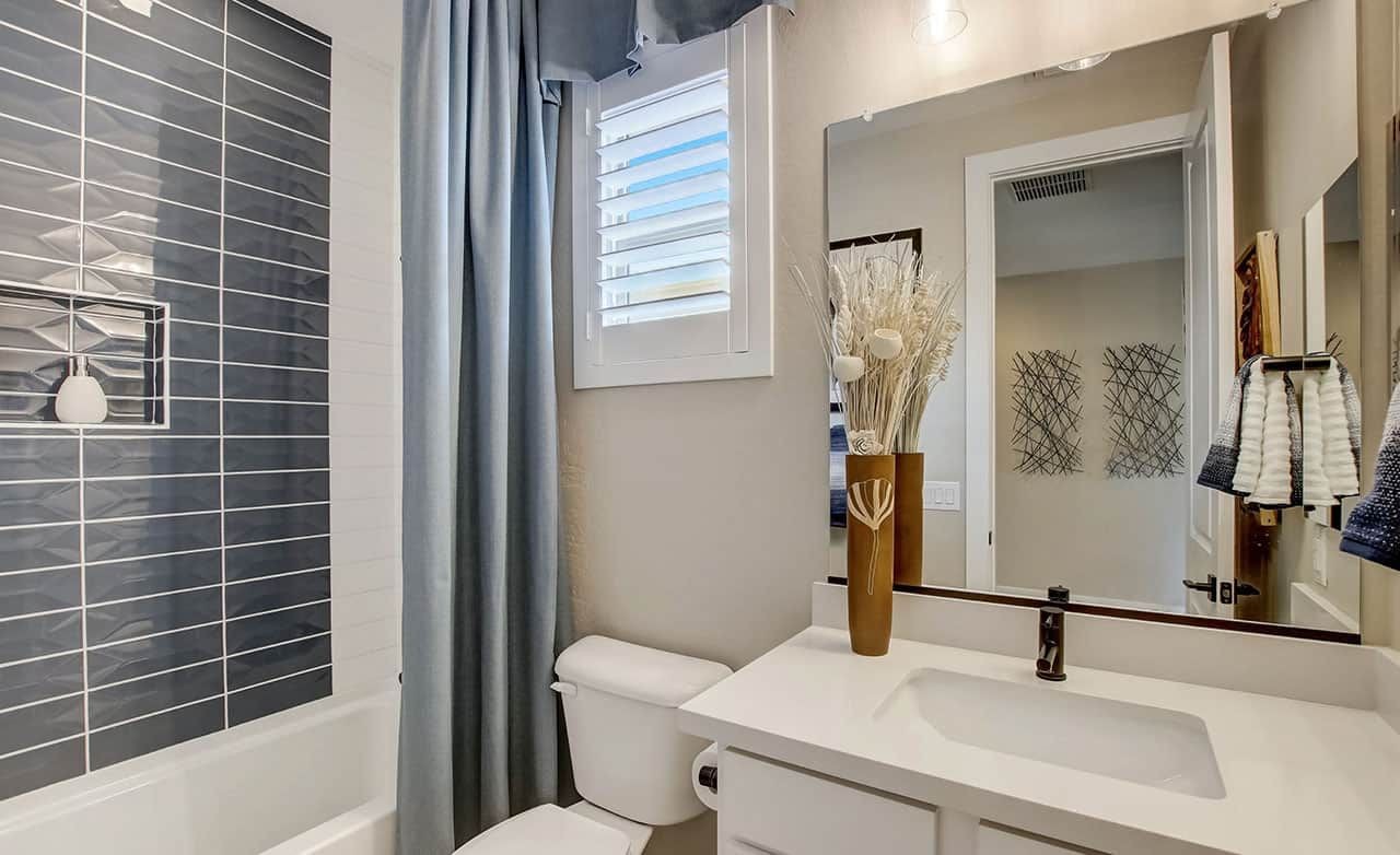 Modern Bathroom at Castillo, Anderson Parc with Gray Tile and White Vanity Modern bathroom with gray tile, white vanity, decorative vase, and window at Castillo, Anderson Parc.