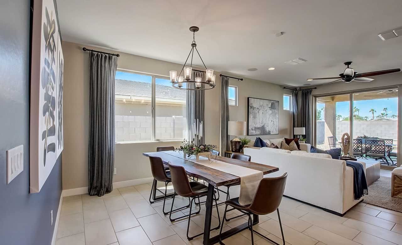 Modern Dining Room in Castillo at Anderson Parc, Arizona Elegant dining room in Castillo at Anderson Parc with modern chandelier, tile floor, and large window.