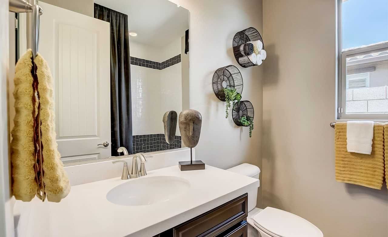 Elegant Bathroom in Castillo at Anderson Parc with Artistic Touches Bathroom in Castillo at Anderson Parc; features white countertop, dark cabinetry, artistic wall decor, window.