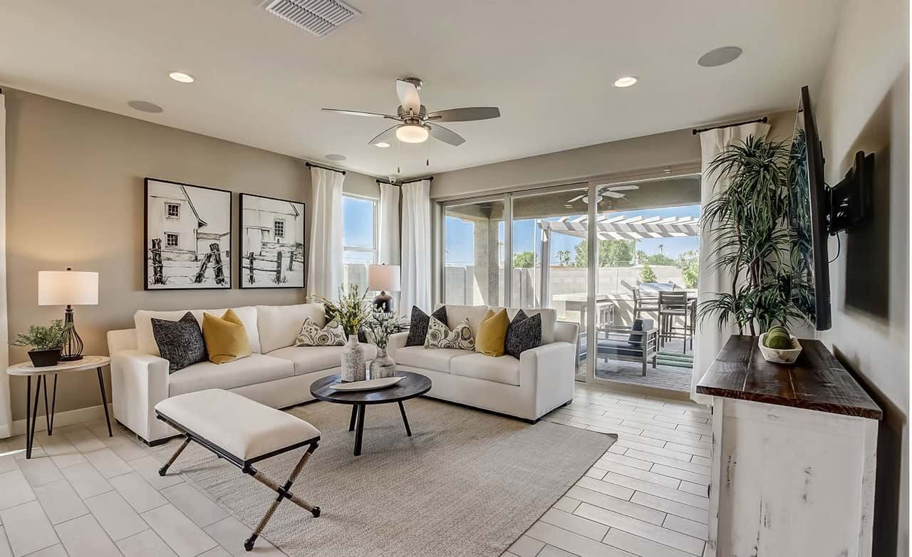 Castillo Living Room with Modern Design at Anderson Parc Modern living room with white sofas, abstract art, sliding glass doors, tile flooring at Castillo, Anderson Parc.
