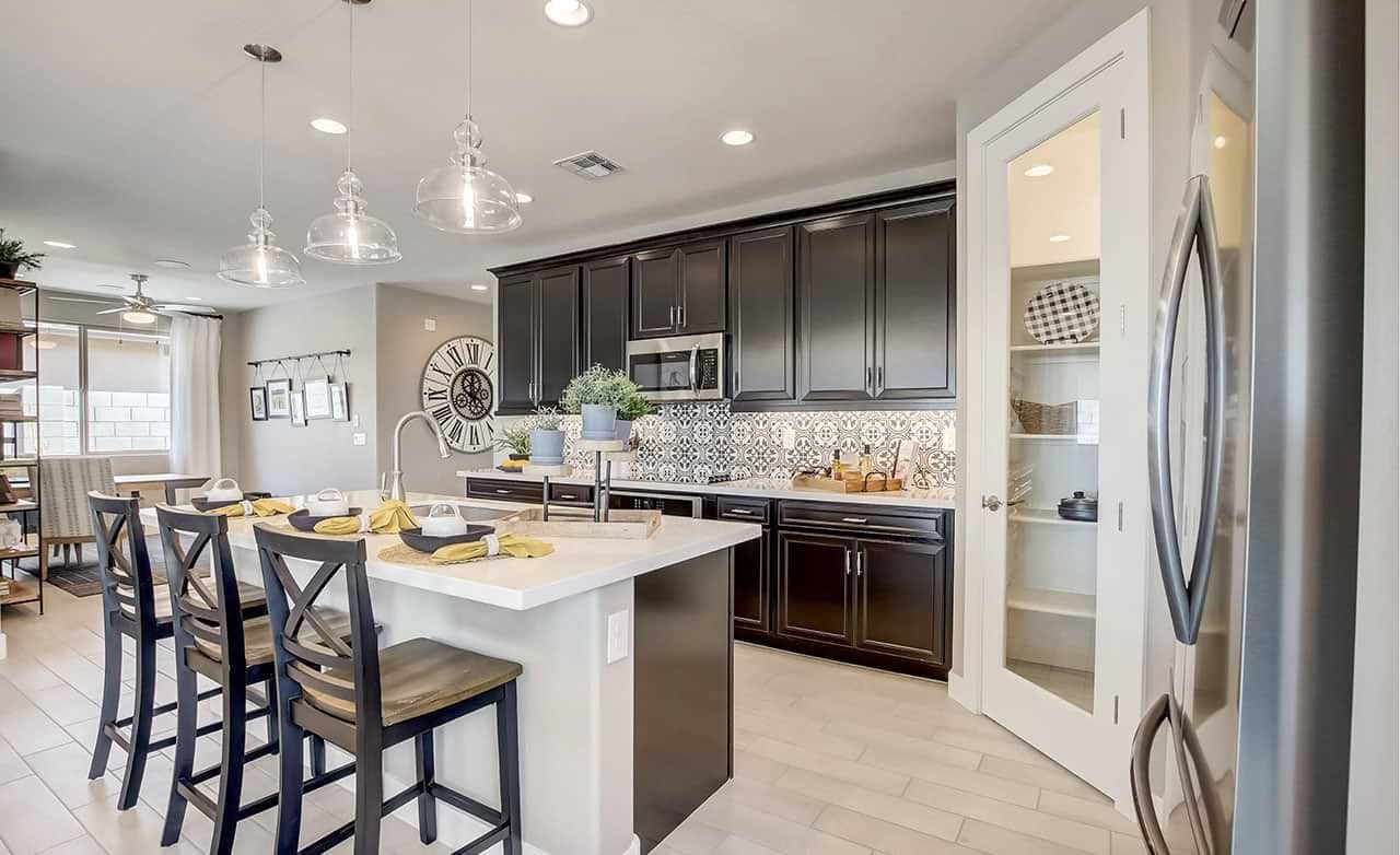 Contemporary Kitchen Design at Castillo, Anderson Parc Modern kitchen with island, pendant lights, dark cabinets, patterned backsplash, at Castillo, Anderson Parc.