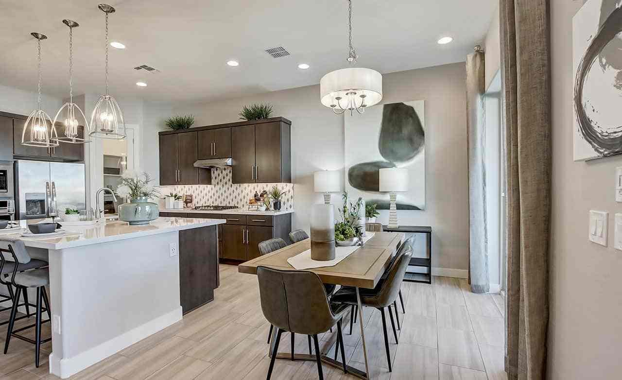 Contemporary Kitchen and Dining Area in Mirada Crossing Modern kitchen in Mirada Crossing with island, pendant lights, and wood cabinets. Sleek dining area adjacent.