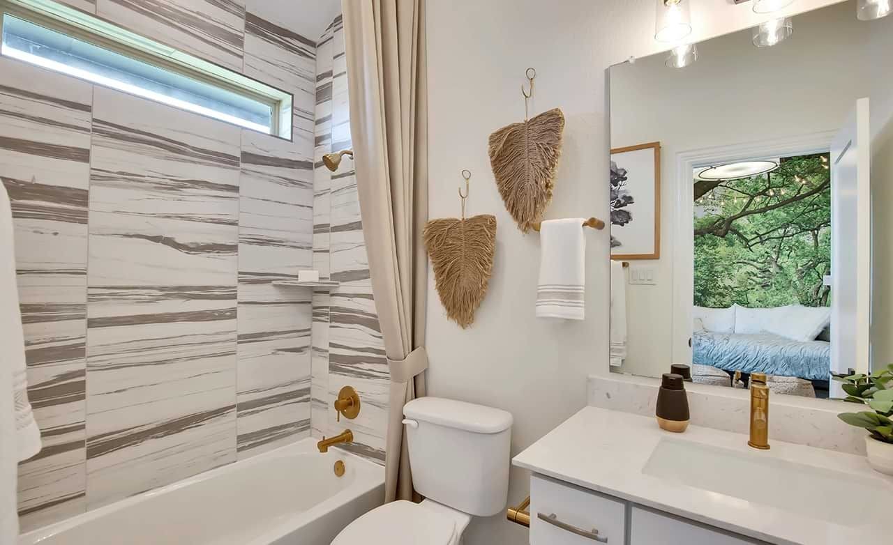 Luxurious Bathroom Design with Marble and Gold in Oaks at San Gabriel Elegant bathroom with marble tiles, gold fixtures, and natural decor in Oaks at San Gabriel home.