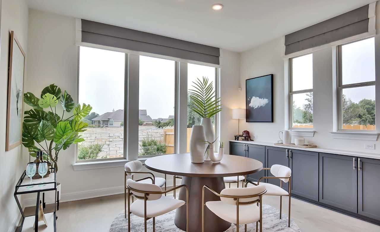 Modern Dining Area in Oaks at San Gabriel, Georgetown, TX Elegant dining area with large windows, modern furniture in Oaks at San Gabriel, Georgetown, TX.