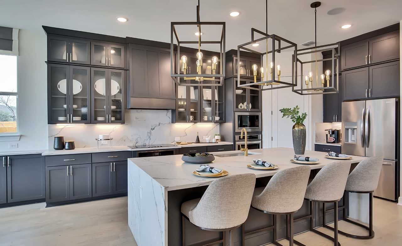 Luxury Kitchen with Marble Island in Oaks at San Gabriel Luxury kitchen with marble island, pendant lights, and dark cabinets in Oaks at San Gabriel community.
